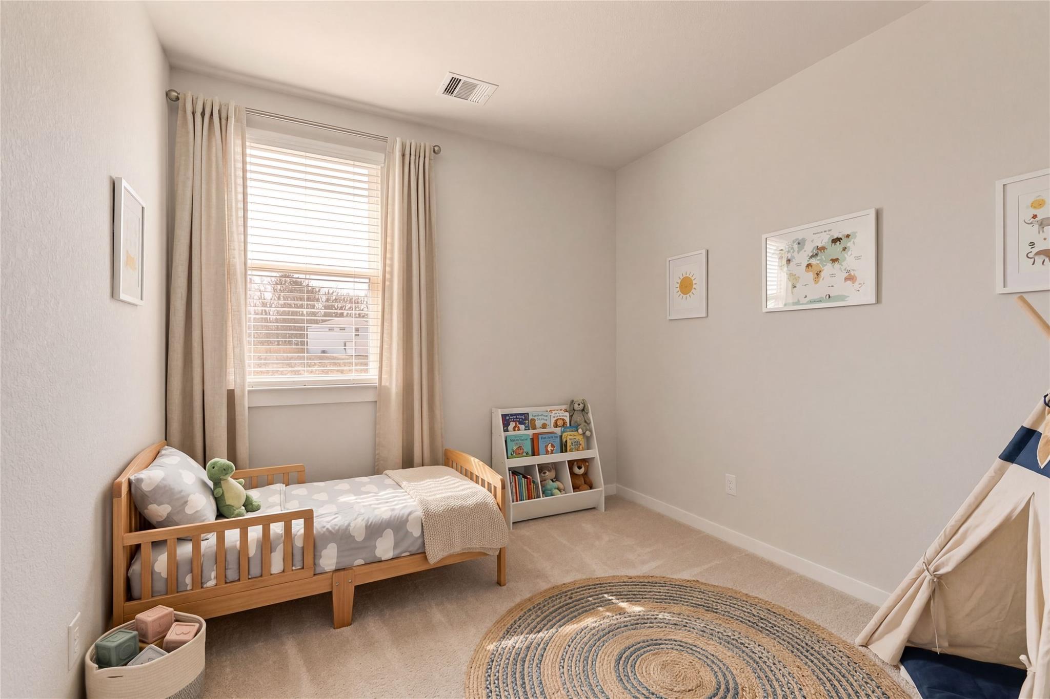Charming toddler bedroom with wooden crib bed, bookshelf, teepee tent, and round rug in Davidson Homes Colorado F, Cleveland, Texas