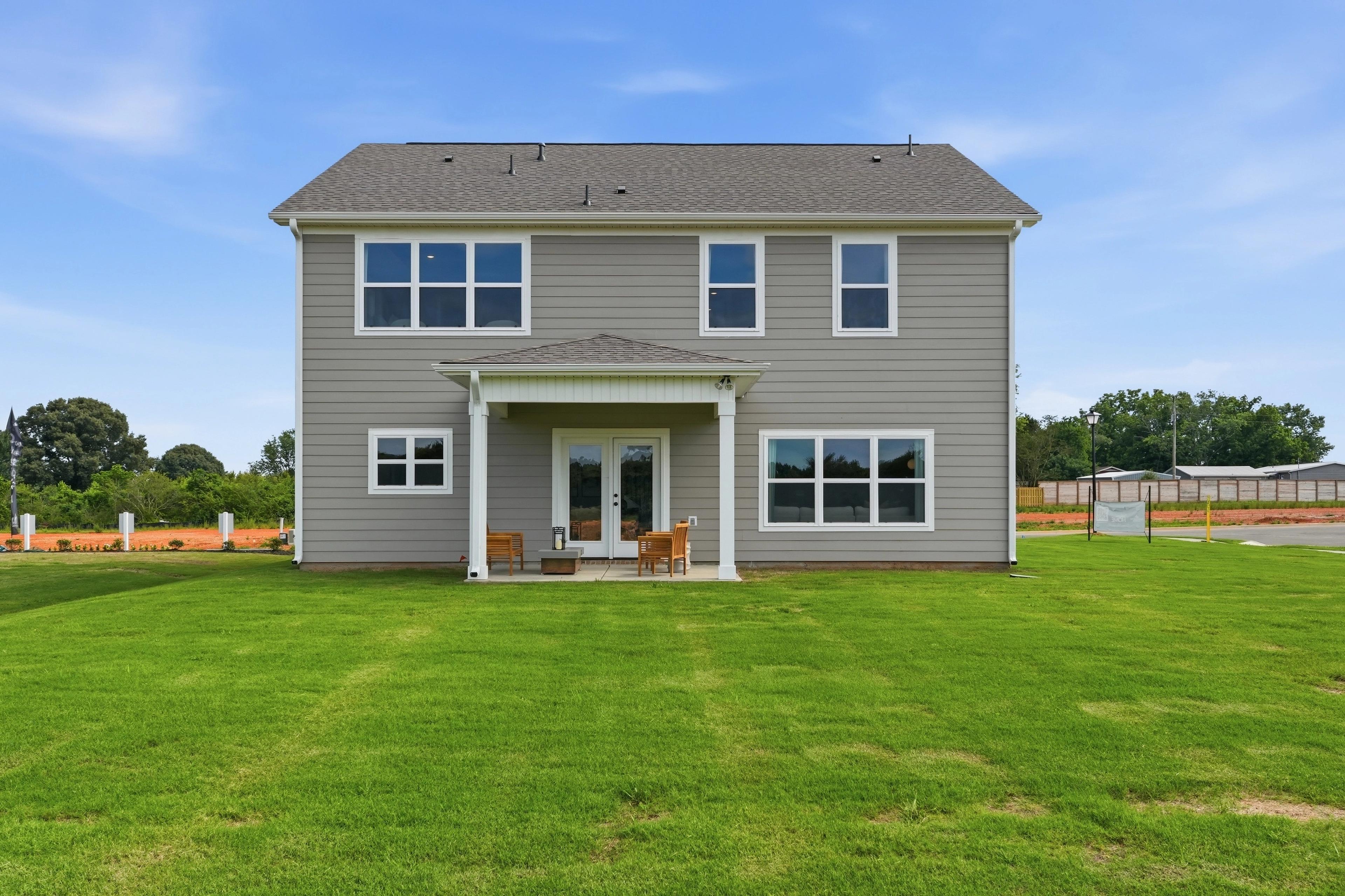Rear view of a Davidson Homes house at Berry Cove in New Market, Alabama, featuring a covered patio and spacious backyard.