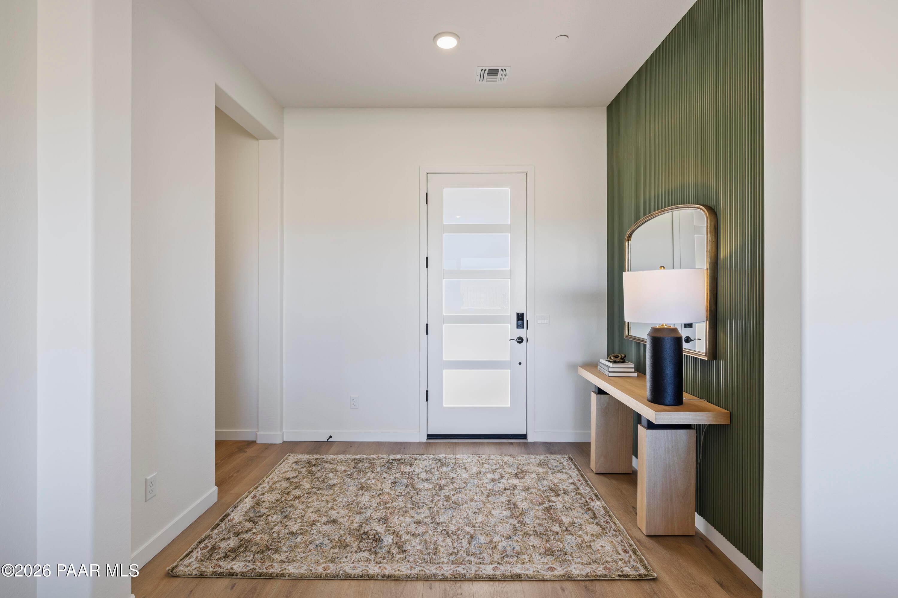 Modern entryway with accent wall, console table, and patterned rug in The Blaze D floor plan at Hidden Hills, Prescott.