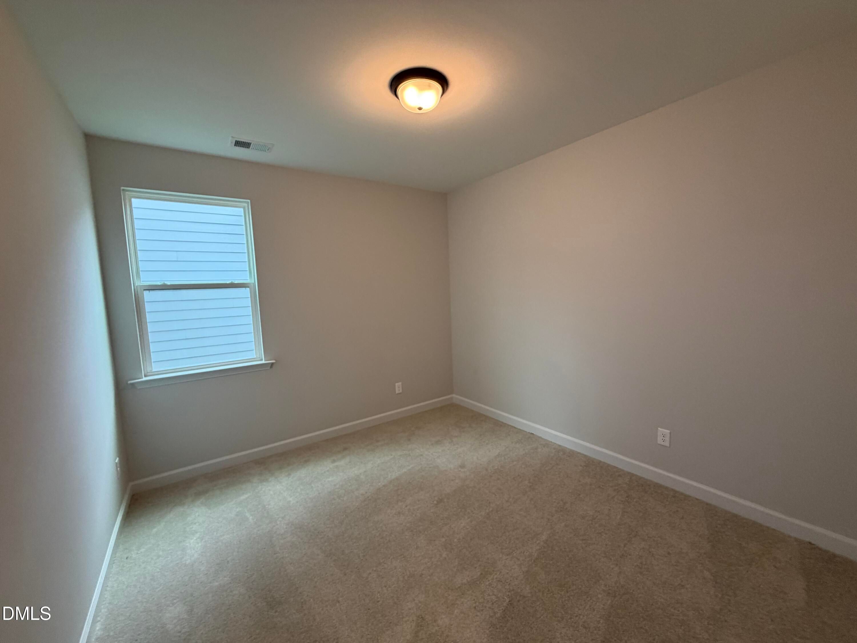 Empty carpeted bedroom with natural light in Davidson Homes The Preston C floor plan at Wendell Ridge, Wendell, North Carolina