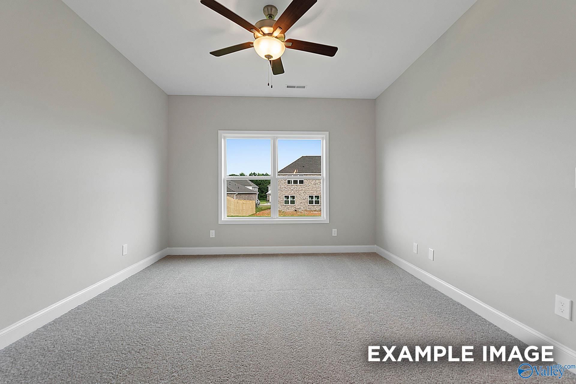 Bright empty bedroom with ceiling fan, large window to neighborhood view in Davidson Homes The Franklin E, Hazel Green, Alabama