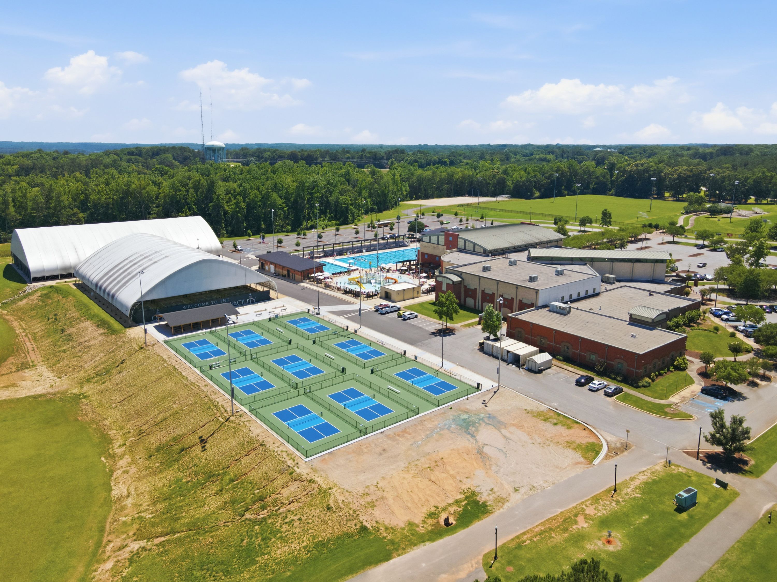 Aerial view of tennis courts, swimming pool, and sports complex at Anderson Lakes in Opelika, AL by Davidson Homes.