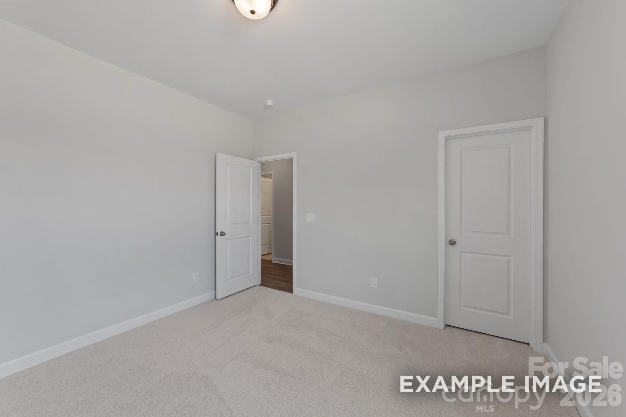 Spacious neutral-toned bedroom in The Magnolia B floor plan by Davidson Homes in Windgate, Mooresville, NC.