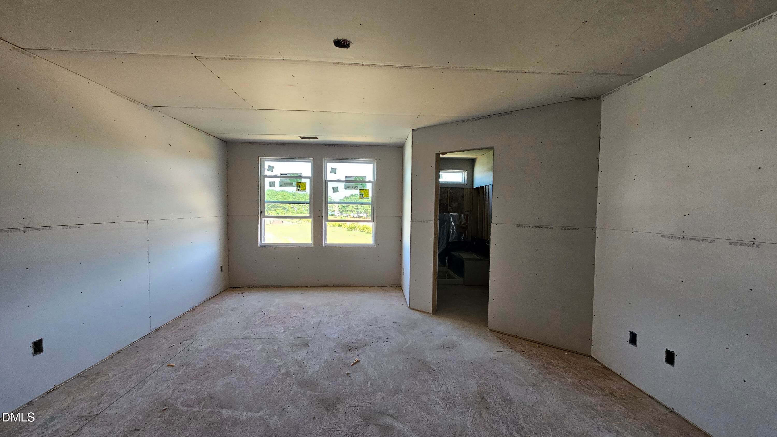 Unfinished bedroom with drywall and natural light in The Graham Interior floor plan at Springvale, Fuquay-Varina.