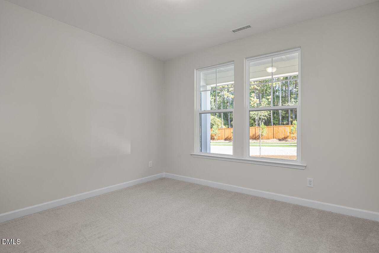 Bright empty bedroom with large windows and wooded view in 4-bedroom The Beech C home, Wake Forest, NC
