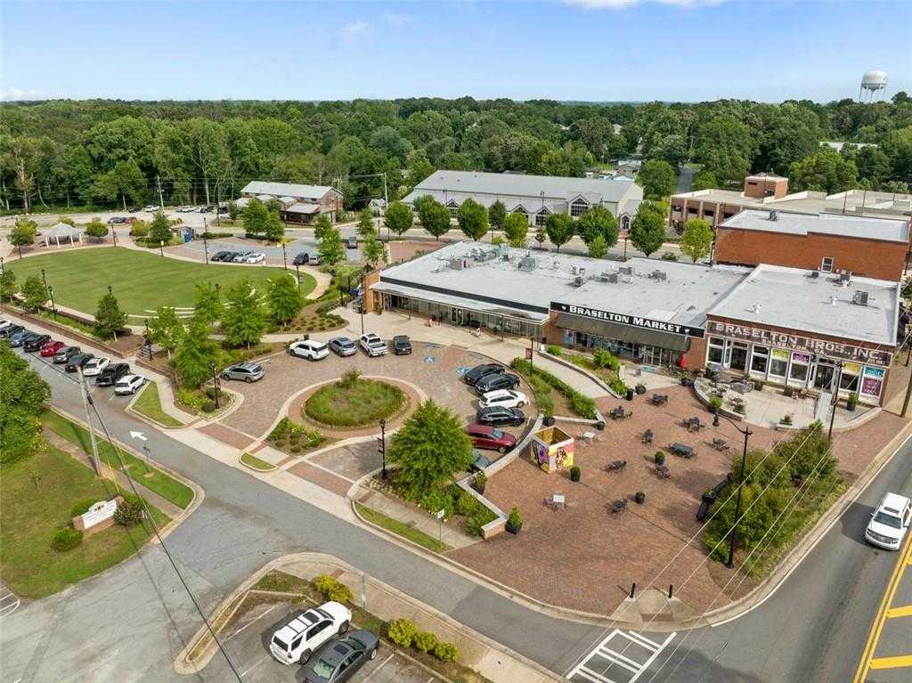 Aerial view of Chastain Market with brick storefronts, outdoor seating, parked cars, and green spaces in Hoschton, Georgia