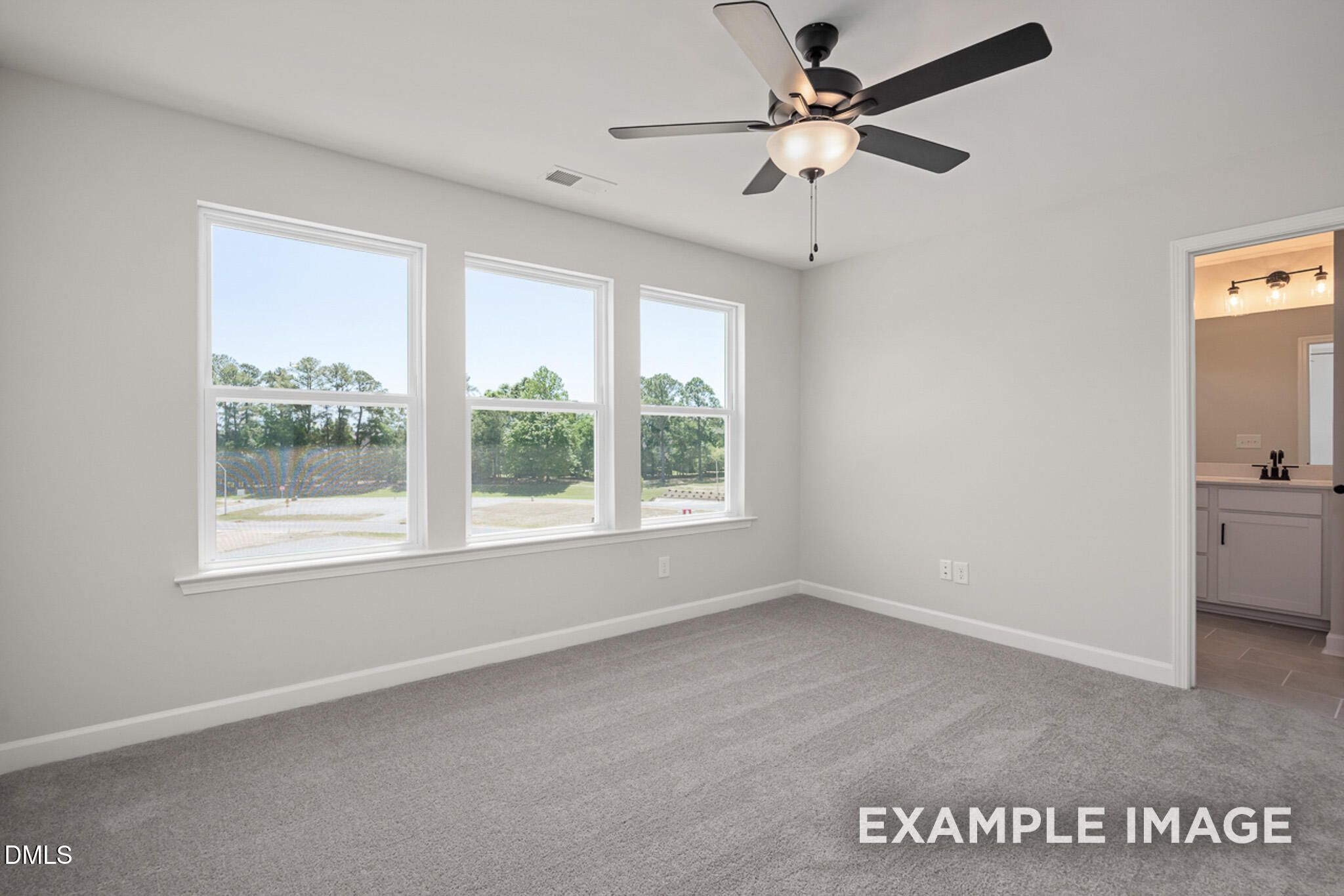 Bright bedroom with ceiling fan and en-suite bathroom in The Mitchell floor plan at Camden Park, Knightdale, NC.