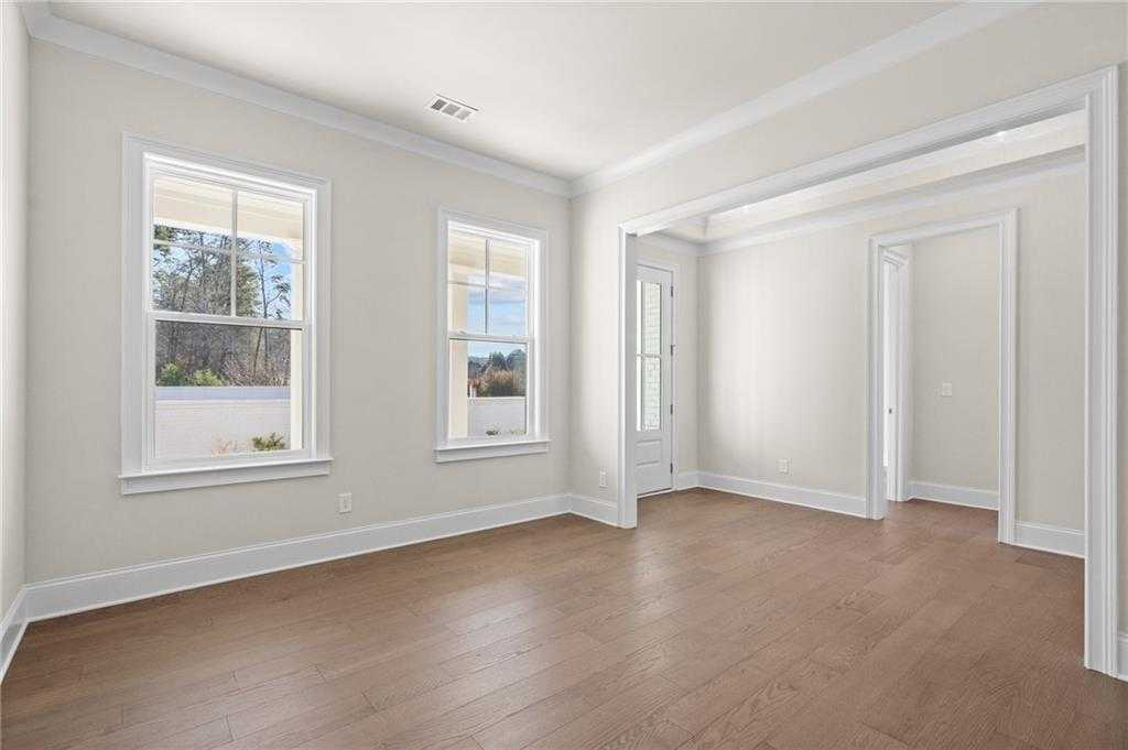 Bright formal living room with hardwood floors, large windows, and open layout in Davidson Homes The Arlington A, East Cobb, GA