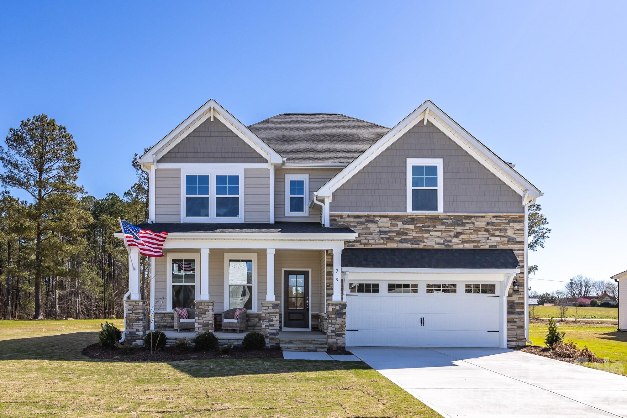 Two-story Hemlock D floor plan by Davidson Homes with stone facade and two-car garage in Enclave at Belmont, North Carolina.