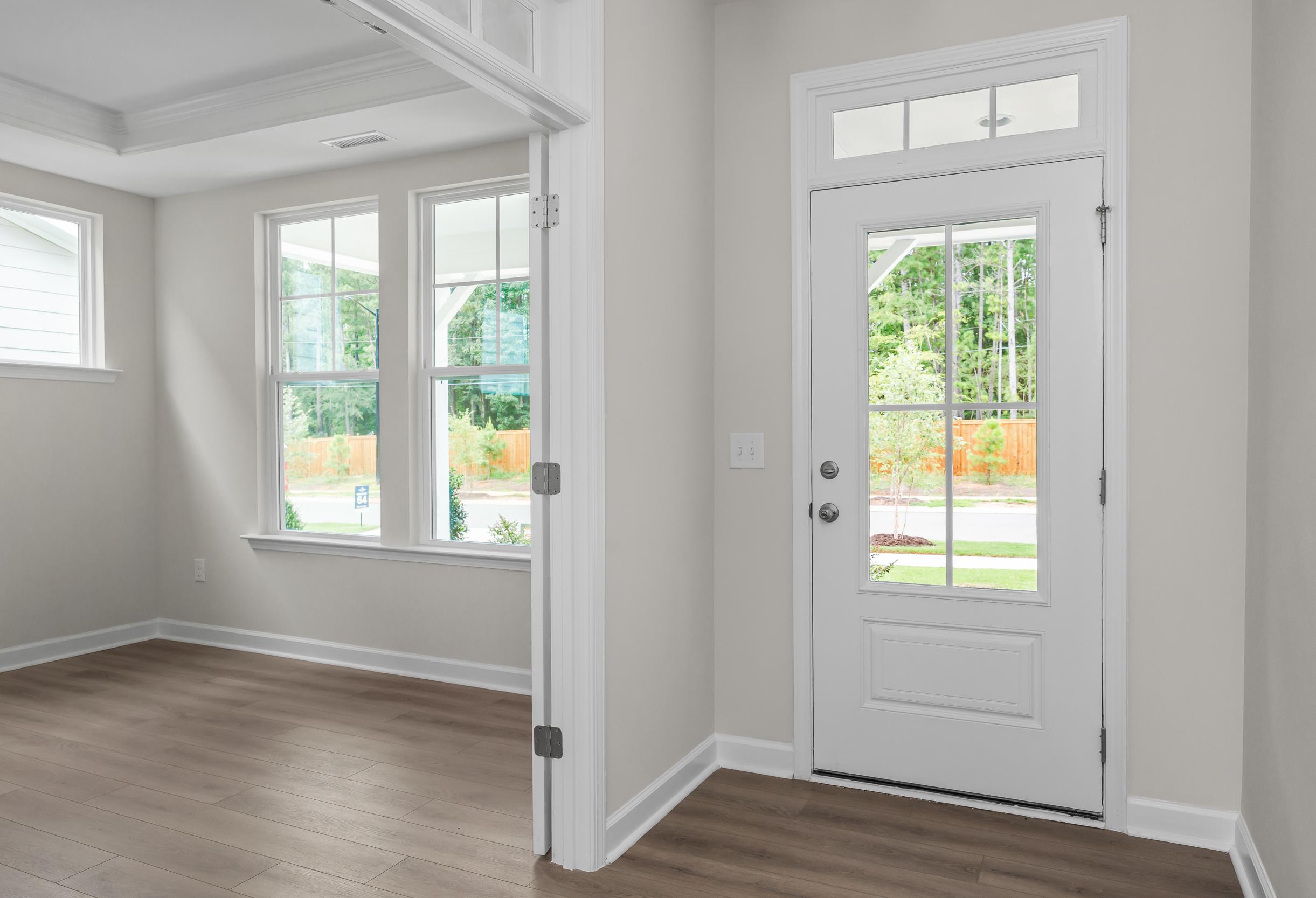 Bright entryway in The Aspen home design with hardwood floors, large windows, and glass-paneled door