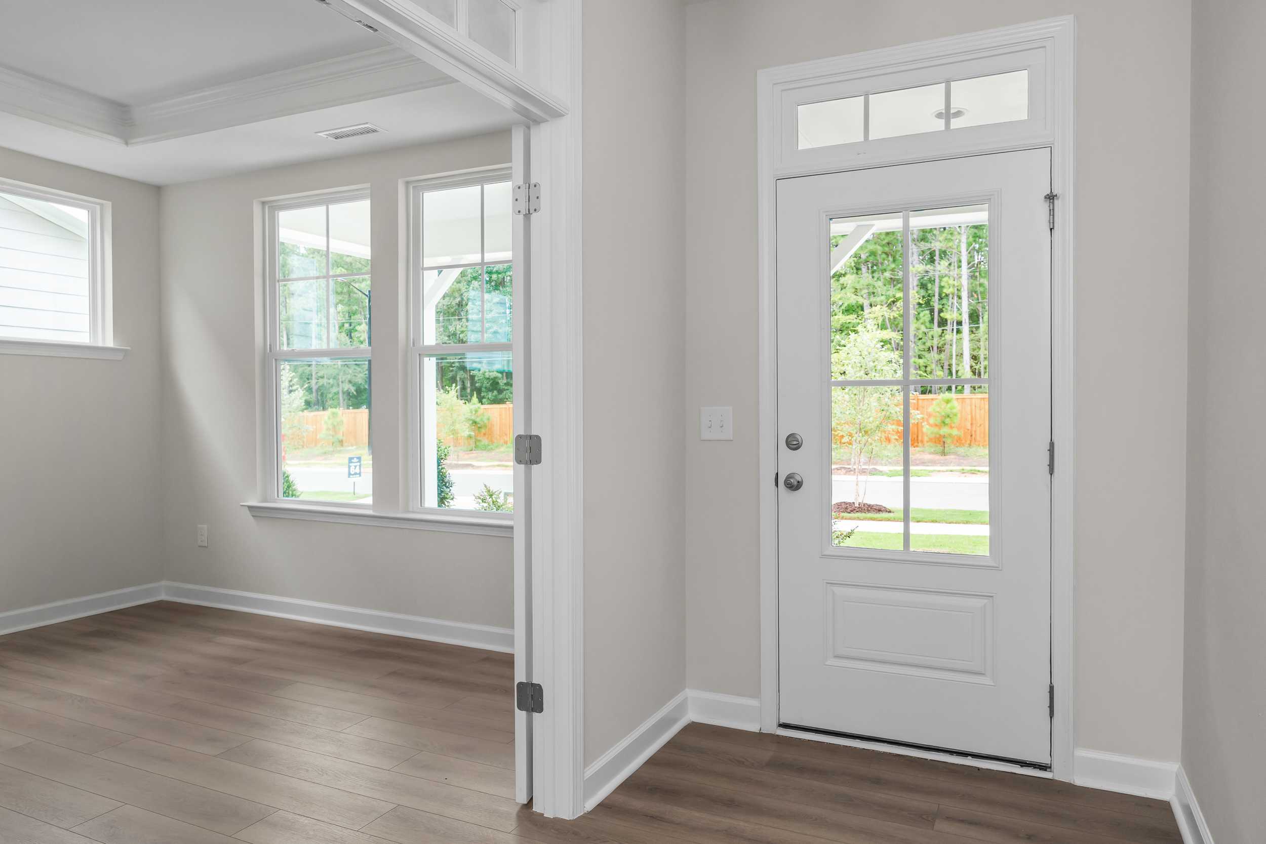 Bright entryway in The Aspen home design with hardwood floors, large windows, and glass-paneled door