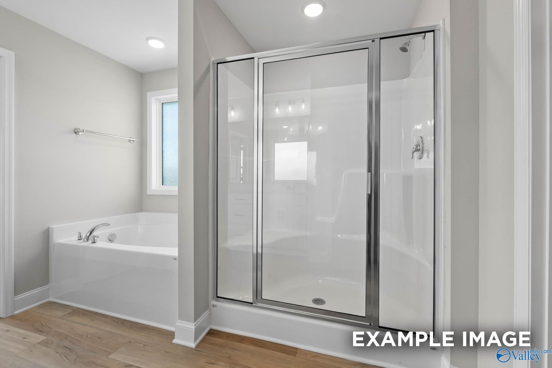 Elegant master bathroom with freestanding tub, glass shower enclosure and neutral tones in Davidson Homes The Chelsea A, Athens, Alabama