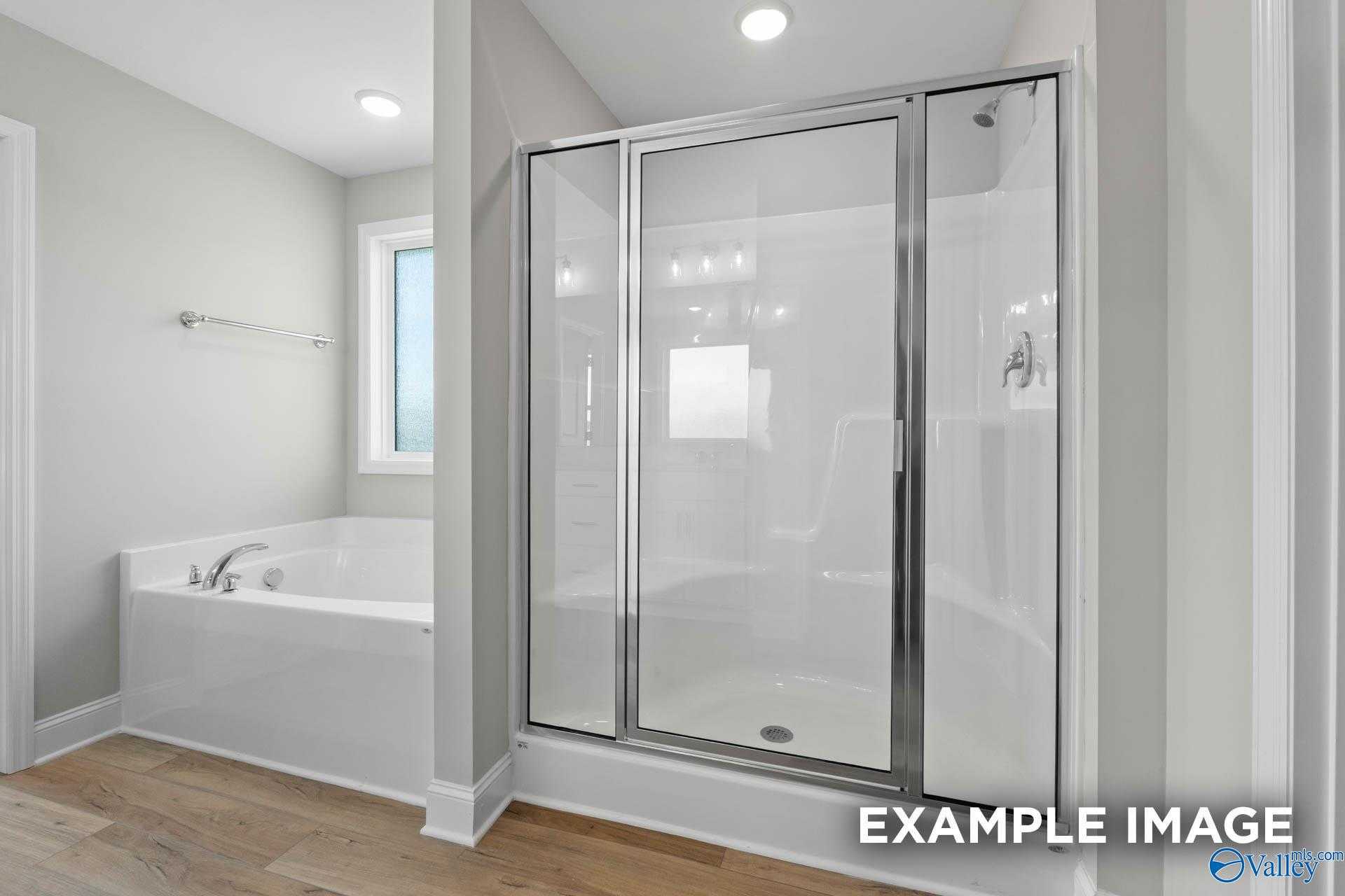 Elegant master bathroom with freestanding tub, glass shower enclosure and neutral tones in Davidson Homes The Chelsea A, Athens, Alabama
