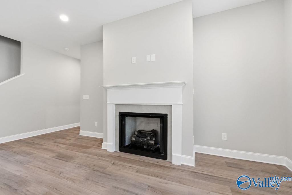 Modern fireplace with white mantel in living room of The Rockford floor plan home in Cain Park, Hartselle, Alabama.
