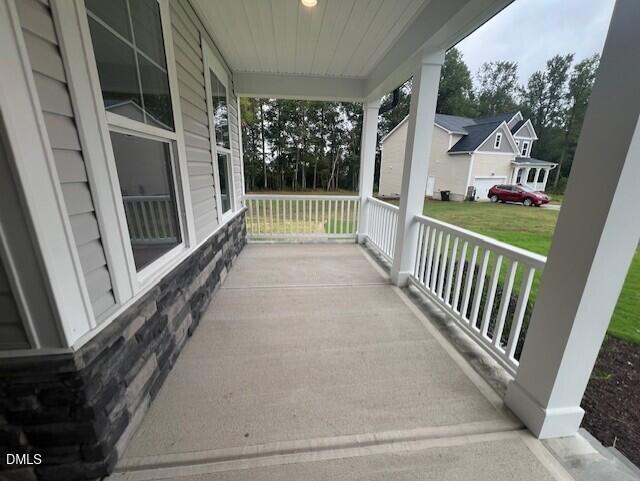 Covered front porch with stone accents and white columns at Davidson Homes The Willow D in Wellers Knoll, Lillington, North Carolina