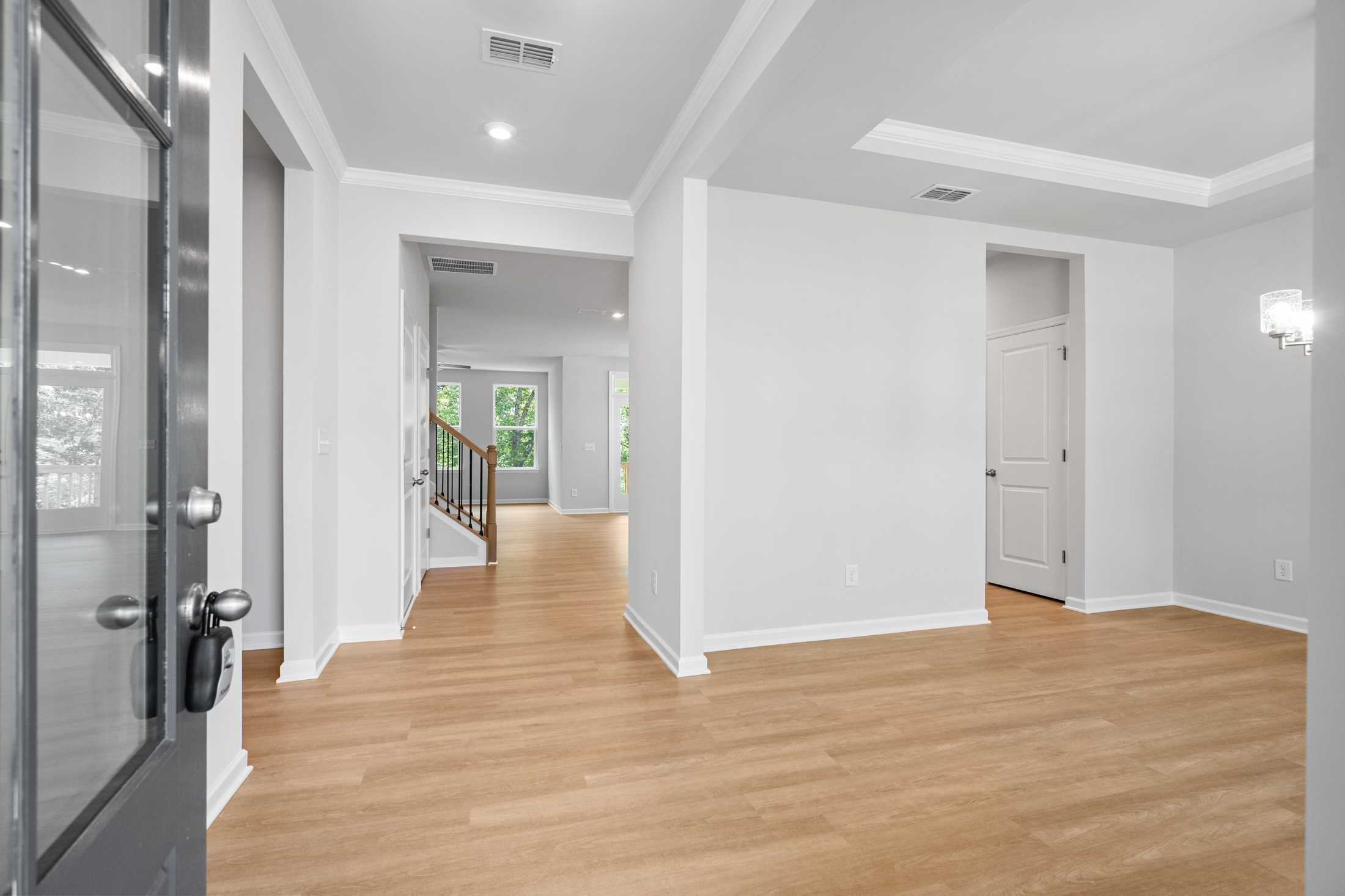 Spacious foyer in The Ash B home at Wehunt Meadows featuring hardwood floors, open staircase, and modern doorways