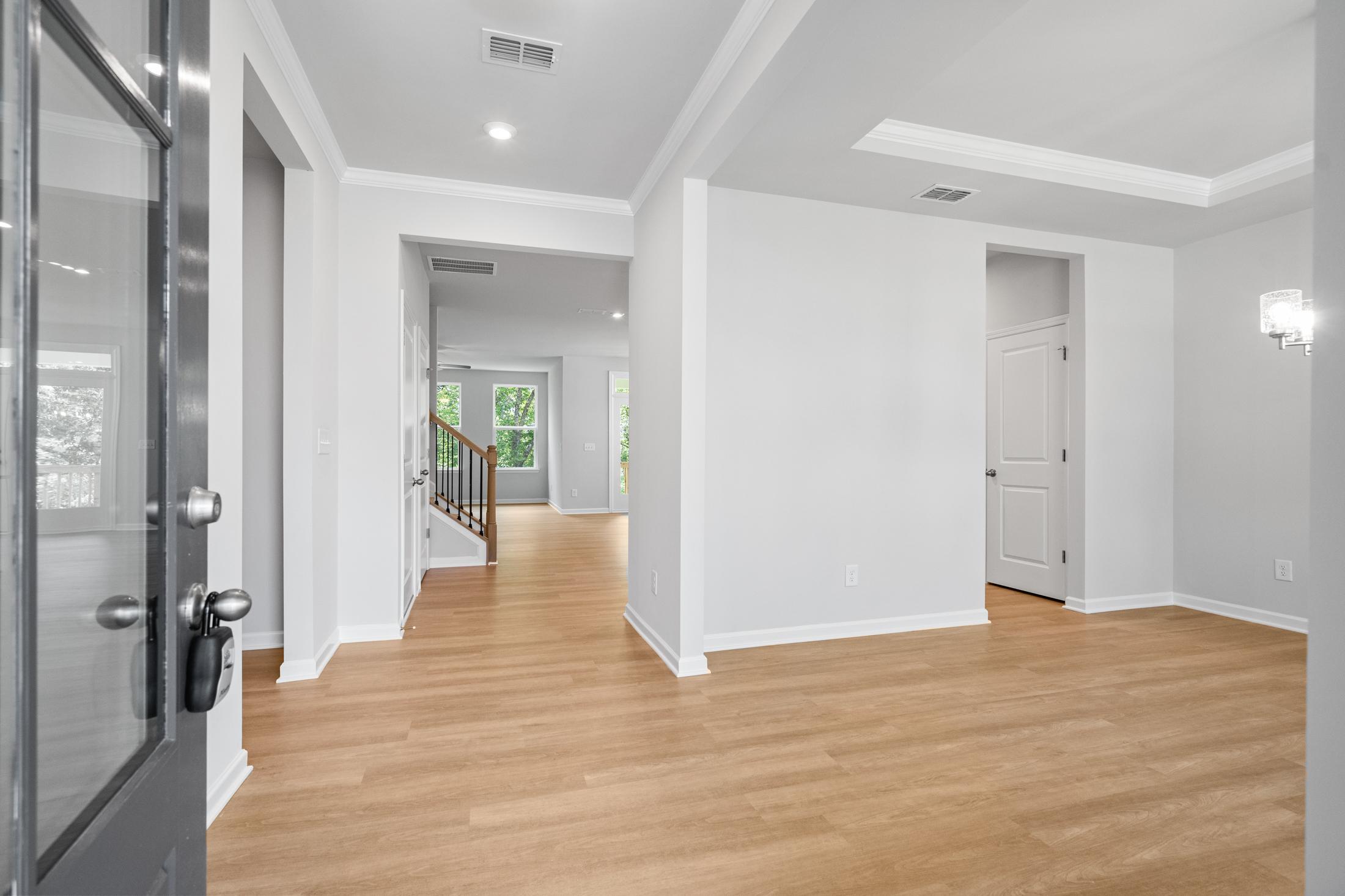 Spacious foyer in The Ash B home at Wehunt Meadows featuring hardwood floors, open staircase, and modern doorways