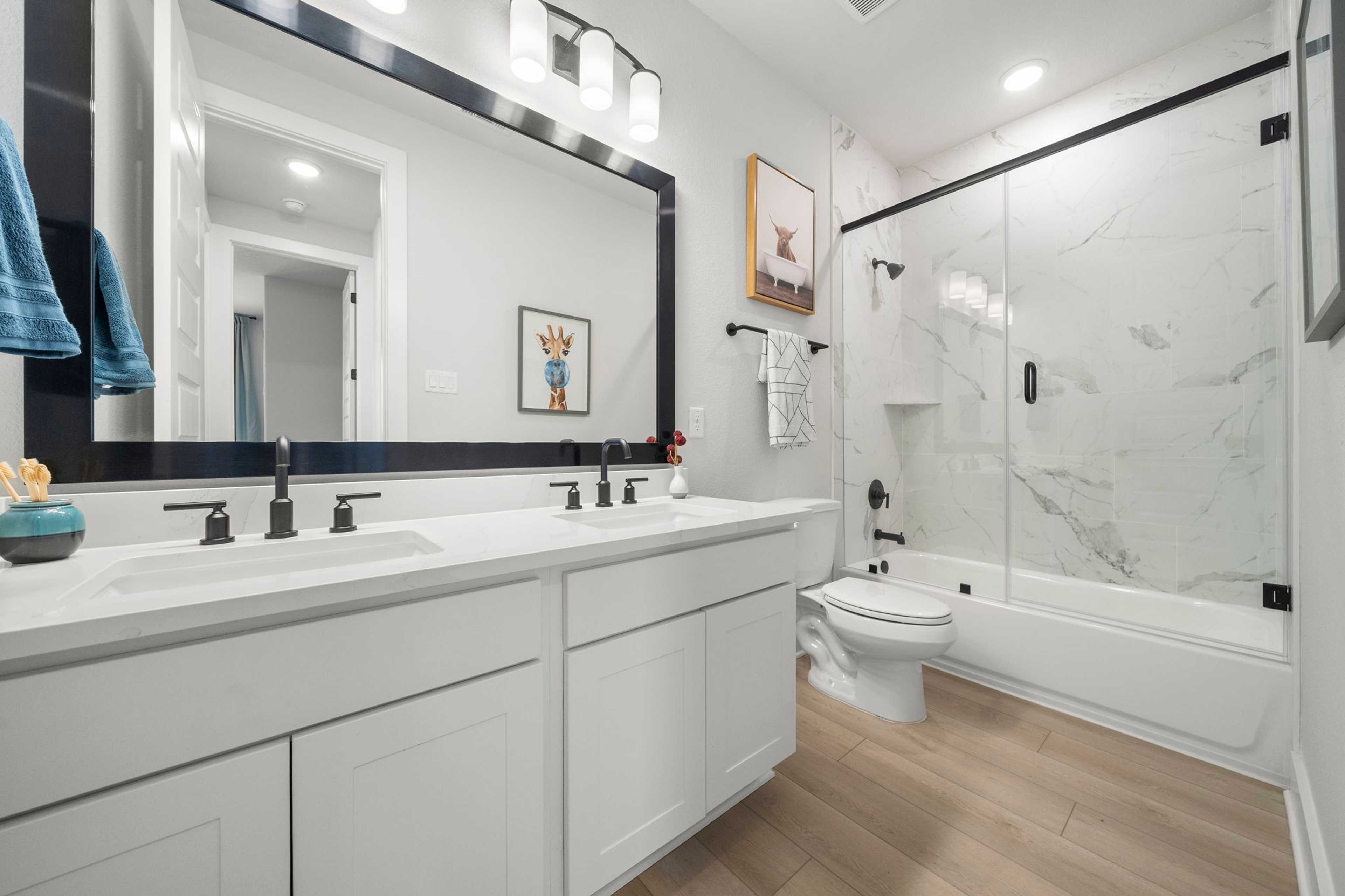 Spacious modern bathroom at Lago Mar in Texas City TX with double vanity, marble shower, soaking tub and hardwood floors