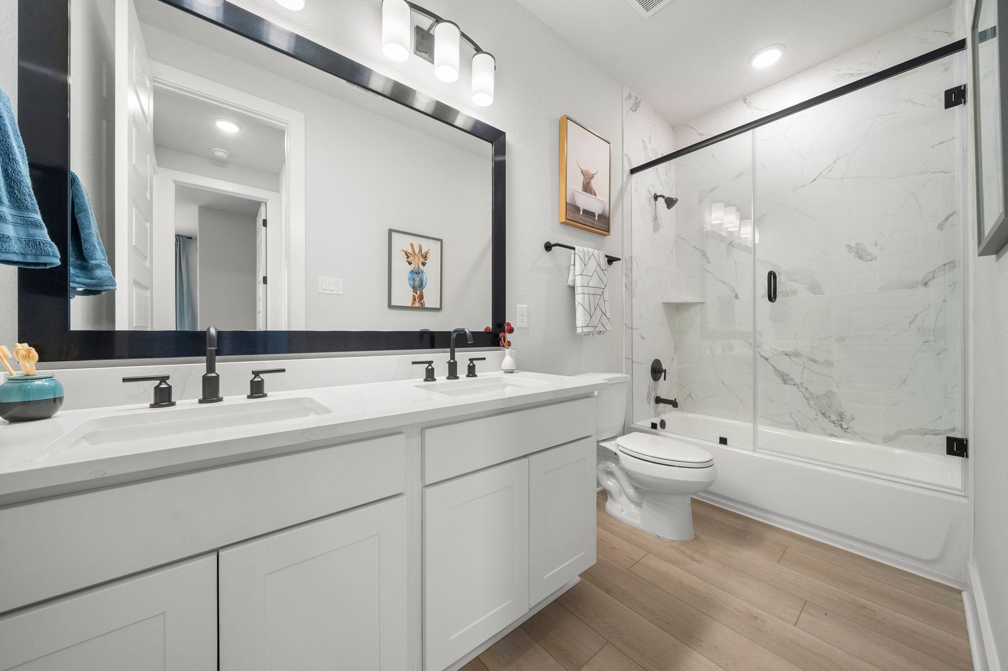 Spacious modern bathroom at Lago Mar in Texas City TX with double vanity, marble shower, soaking tub and hardwood floors
