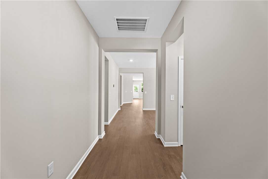 Elegant hallway with hardwood floors and neutral walls in The Orion 4-bedroom home by Evermore Homes, Cusseta, Alabama