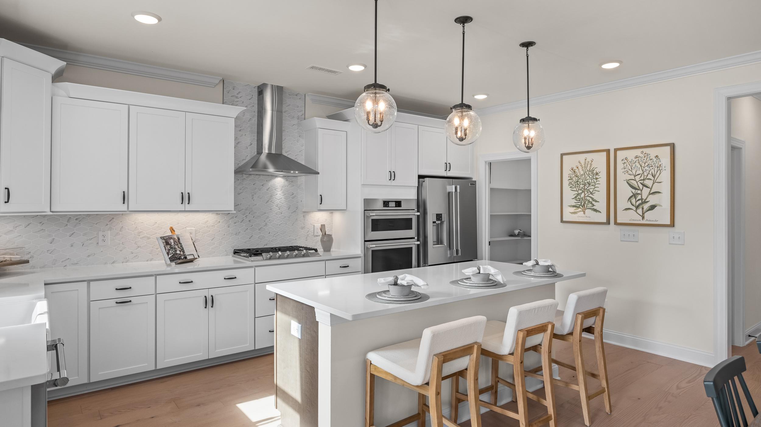 Modern white kitchen with island bar seating in Ashland, Apex NC by Davidson Homes, subway tile backsplash, hardwood floors