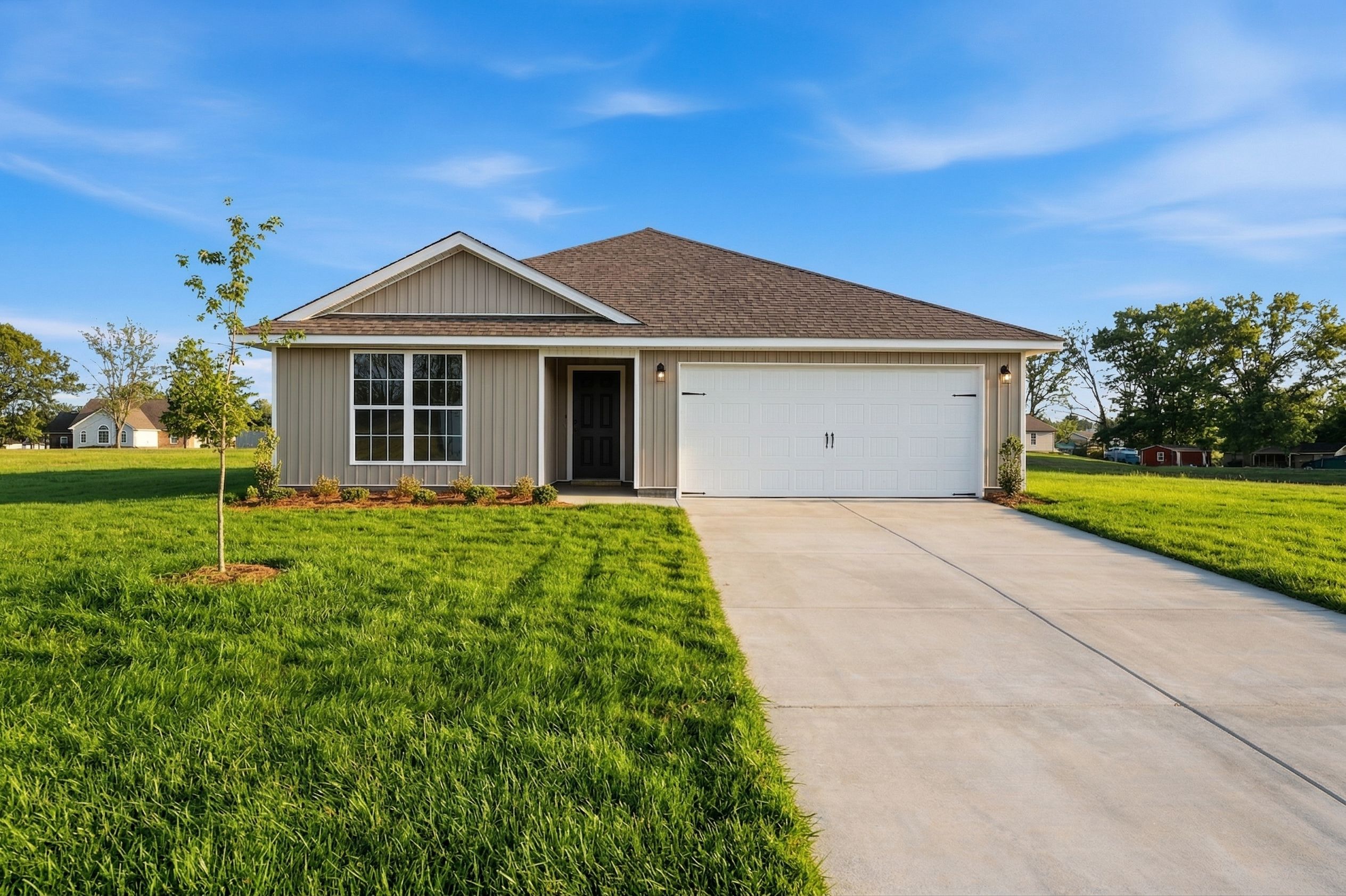 Single-story beige home exterior at Chapel Hill in Athens Alabama with attached garage, front porch, and landscaped green yard