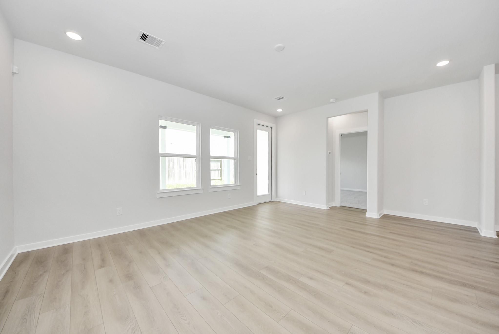 Bright, open-concept living area with light wood floors in The Verano B floor plan by Davidson Homes in Sunterra, Katy.