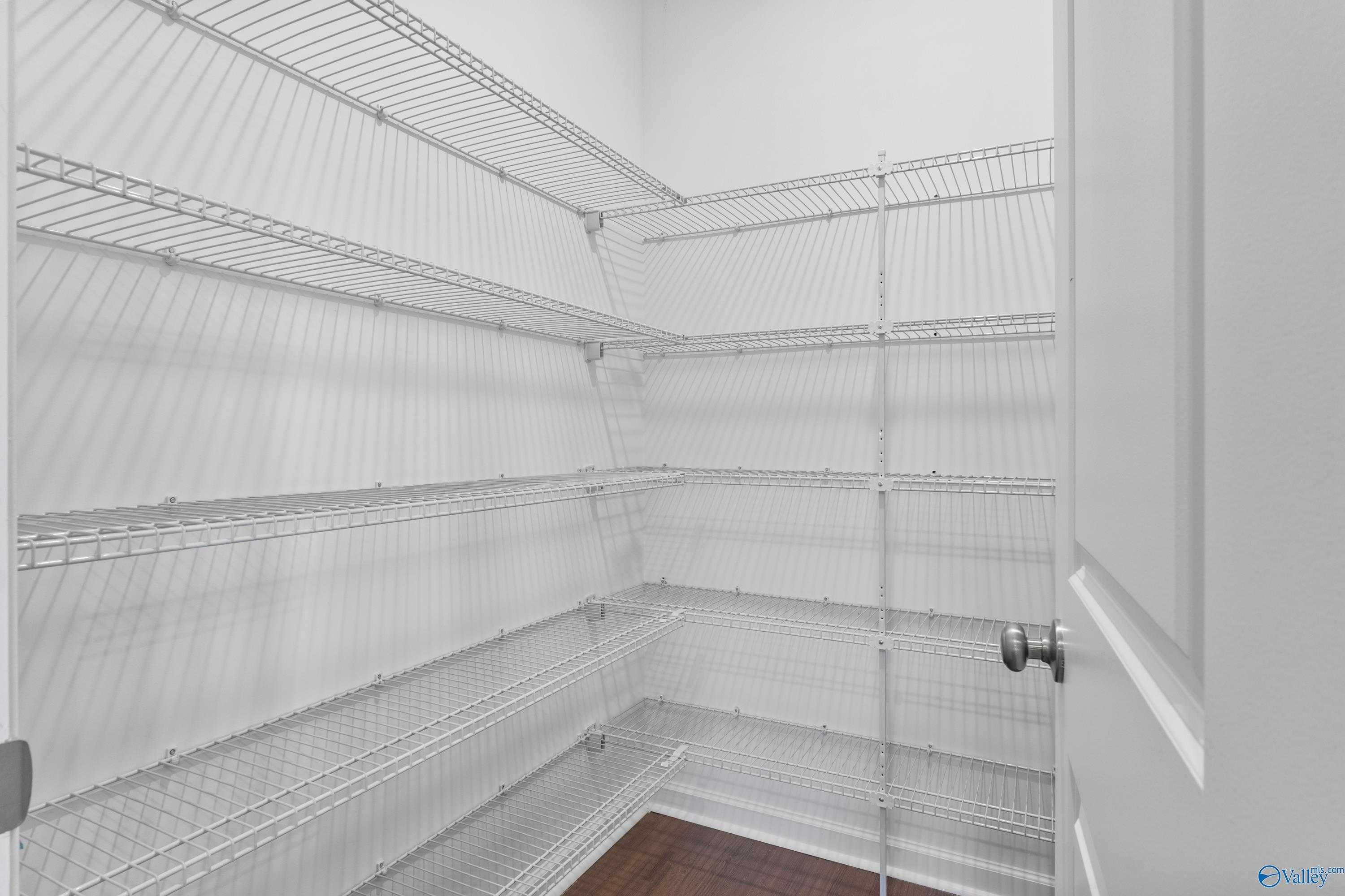 Spacious walk-in pantry with white wire shelving in Davidson Homes The Sanctuary, 4-bedroom home, Riverton Preserve, Huntsville, Alabama