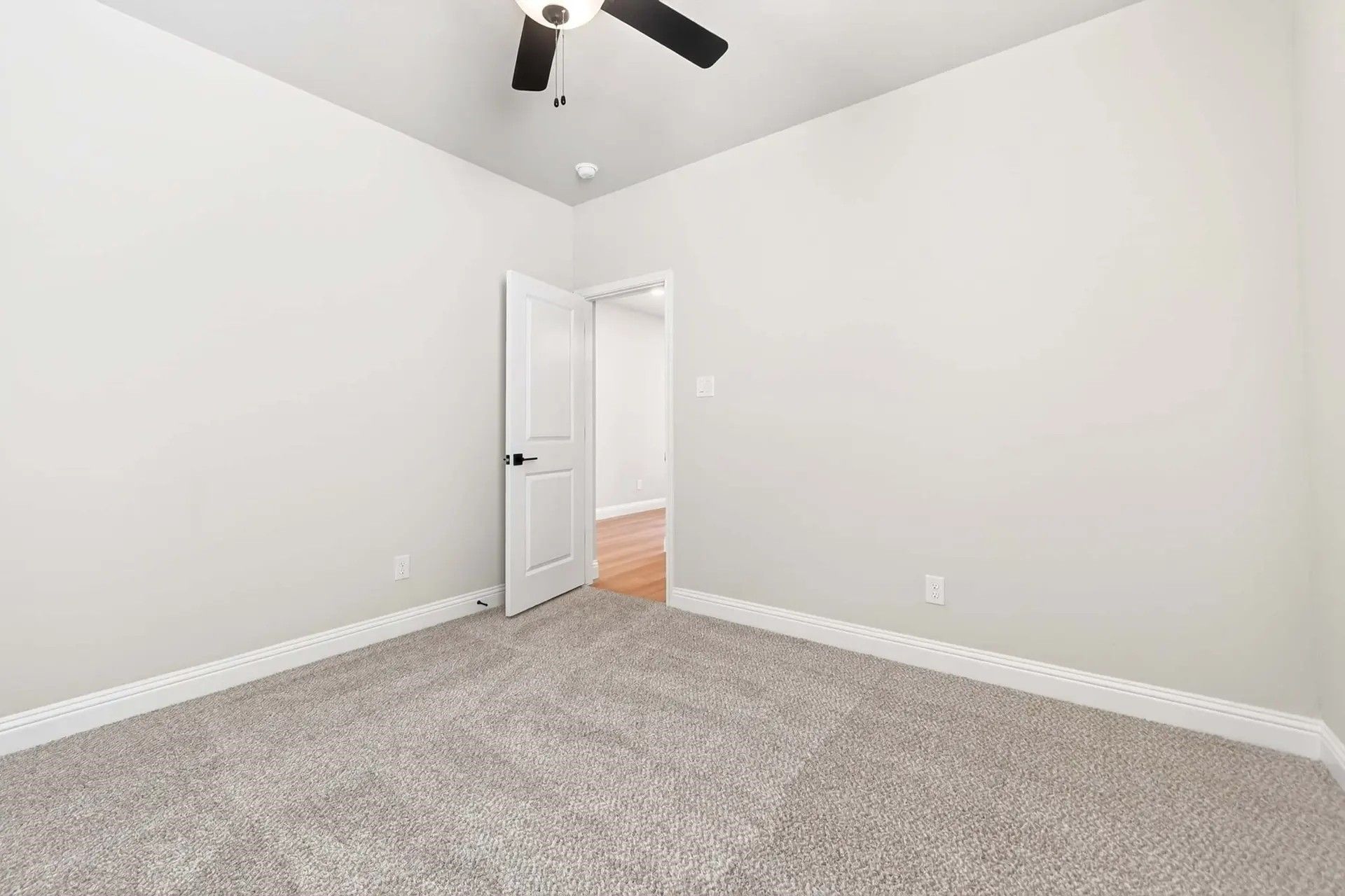 Spacious carpeted bedroom with ceiling fan in The Holly C floor plan by Davidson Homes in Heartland, Texas.