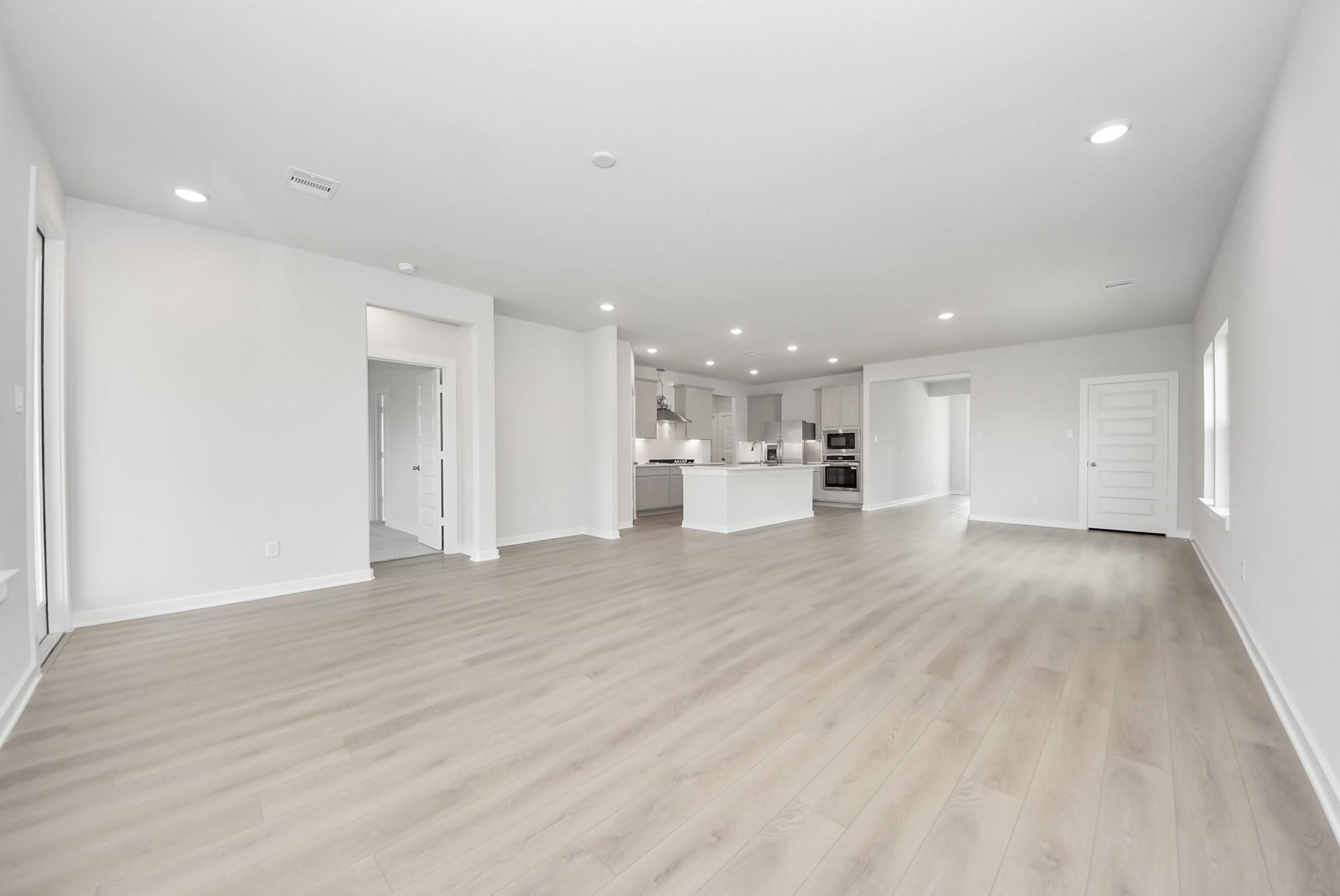 Open-concept living room and kitchen in The Verano B floor plan by Davidson Homes in Sunterra, Katy, Texas.