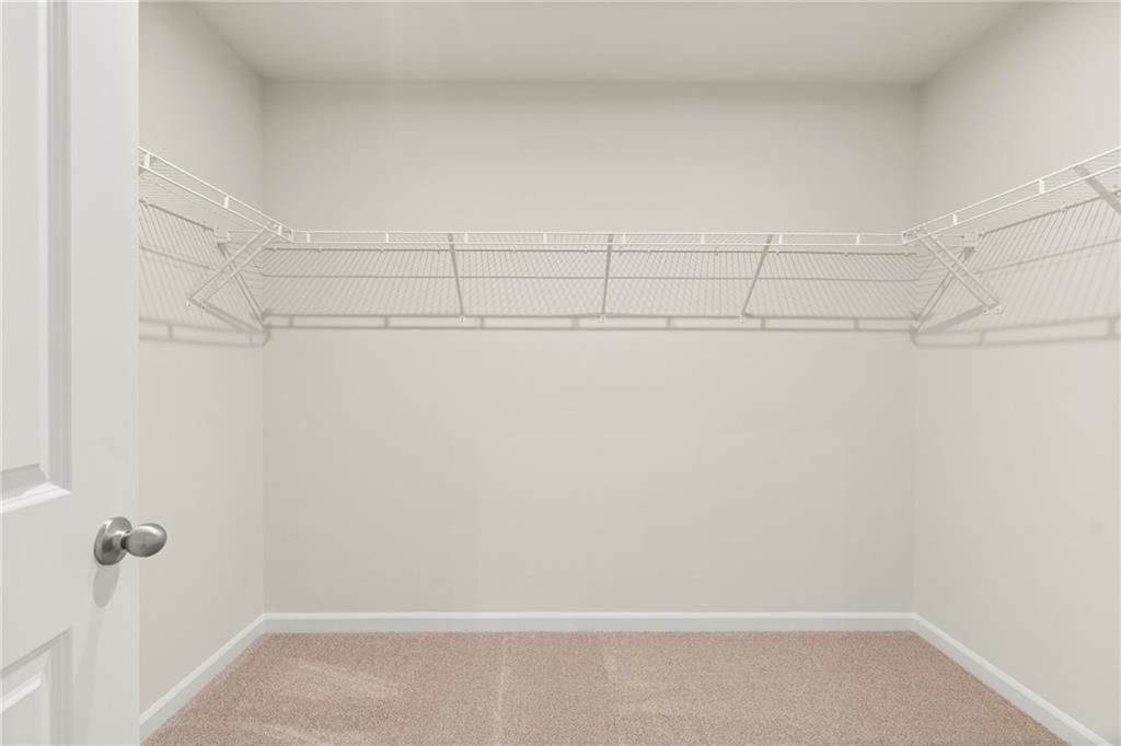 Spacious walk-in closet with wire shelving and double hanging rods in Davidson Homes The Cary A, Kennesaw, Georgia