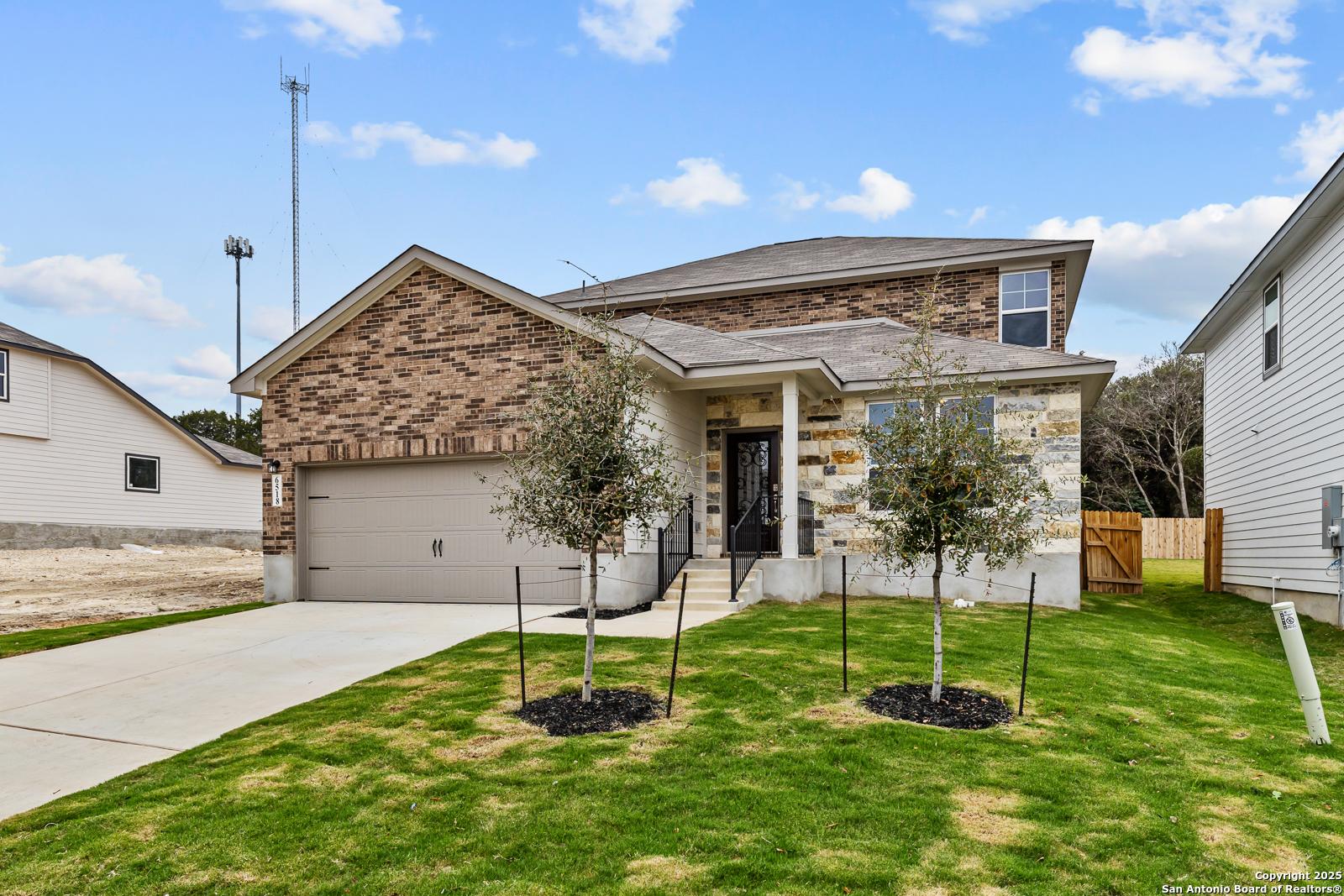 Two-story brick home with two-car garage, olive trees, and landscaped yard in Royal Crest, San Antonio, Texas