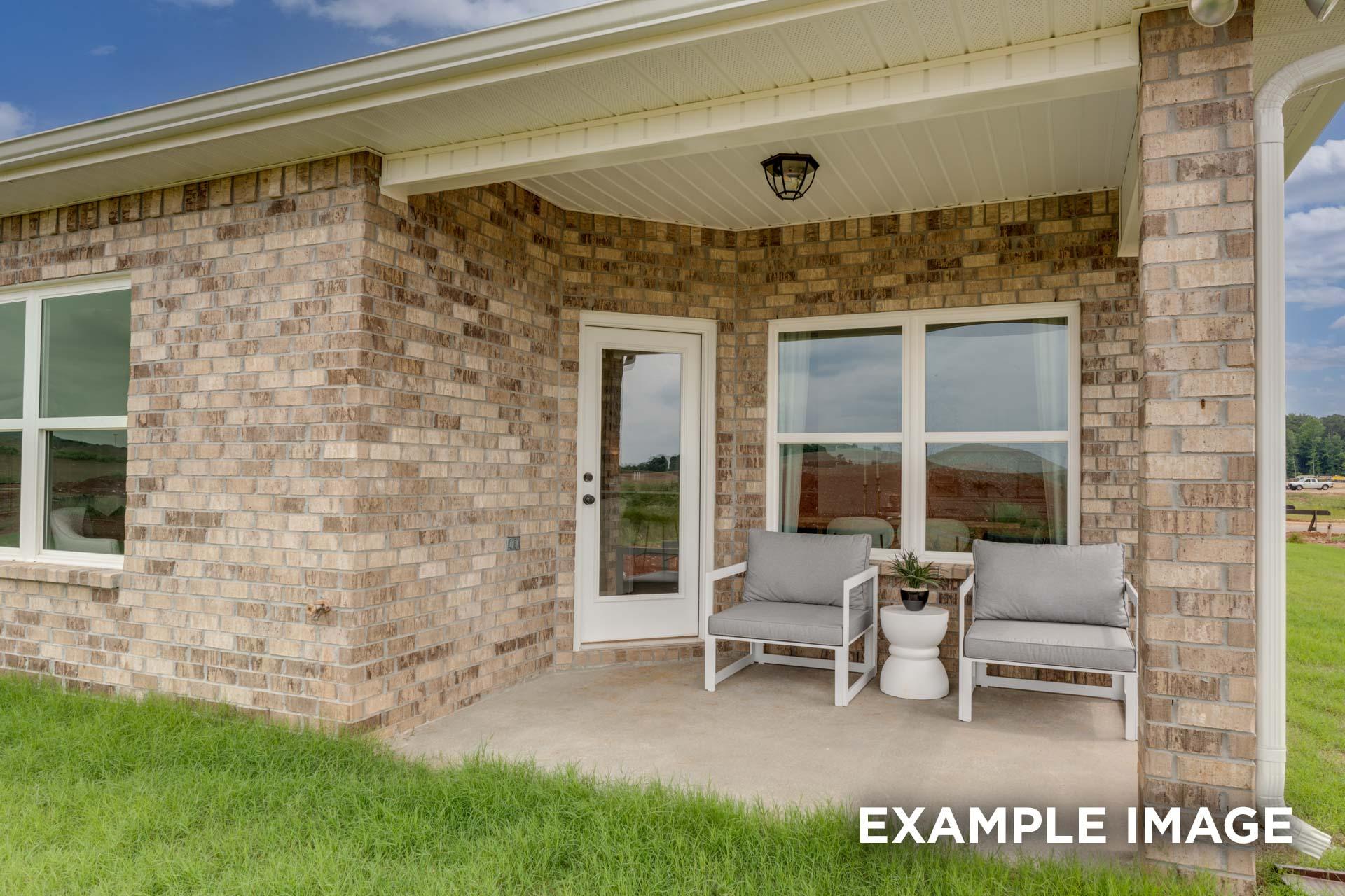 The Laurel M brick exterior single-story home with covered porch, white chairs, round table, and potted plant in Royse City