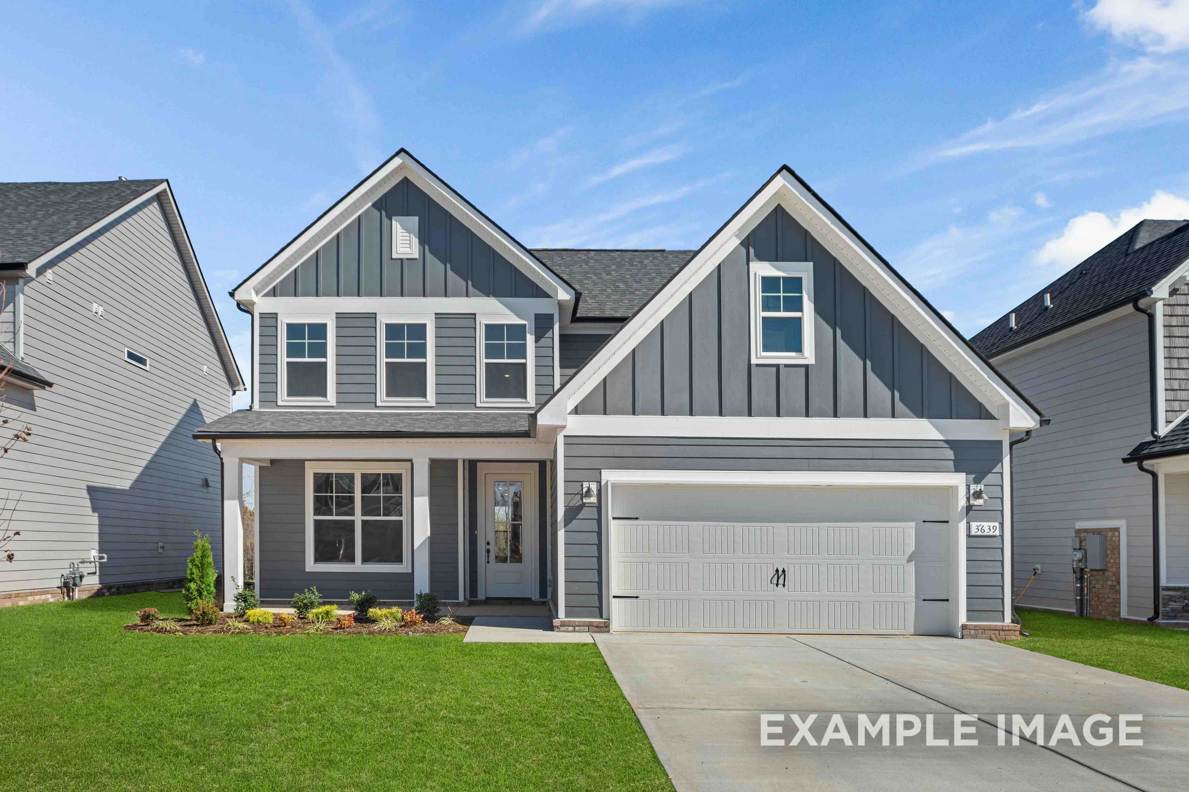 Modern two-story elevation of The Ash home with gray siding, gabled roof, covered porch, and two-car garage in Royse City