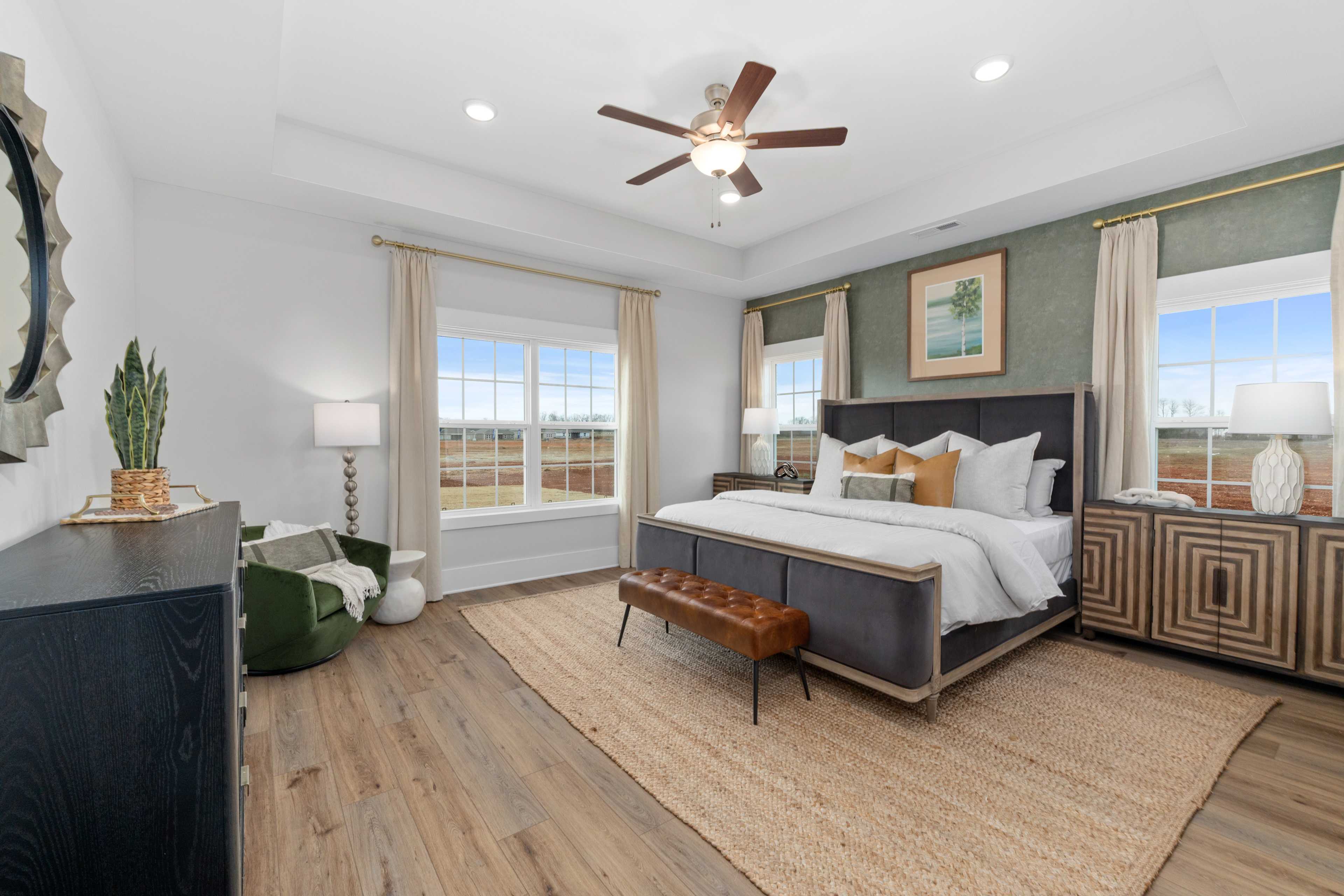 Spacious master bedroom at Briercreek in Meridianville, Alabama with king bed, hardwood floors, ceiling fan and large windows