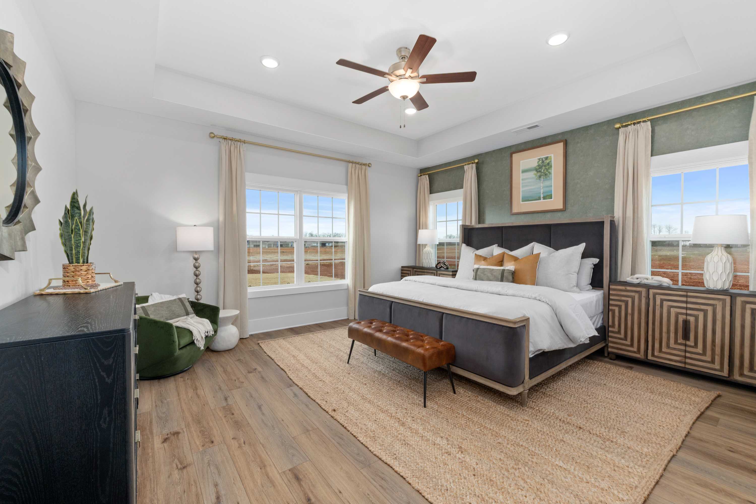 Spacious master bedroom at Briercreek in Meridianville, Alabama with king bed, hardwood floors, ceiling fan and large windows