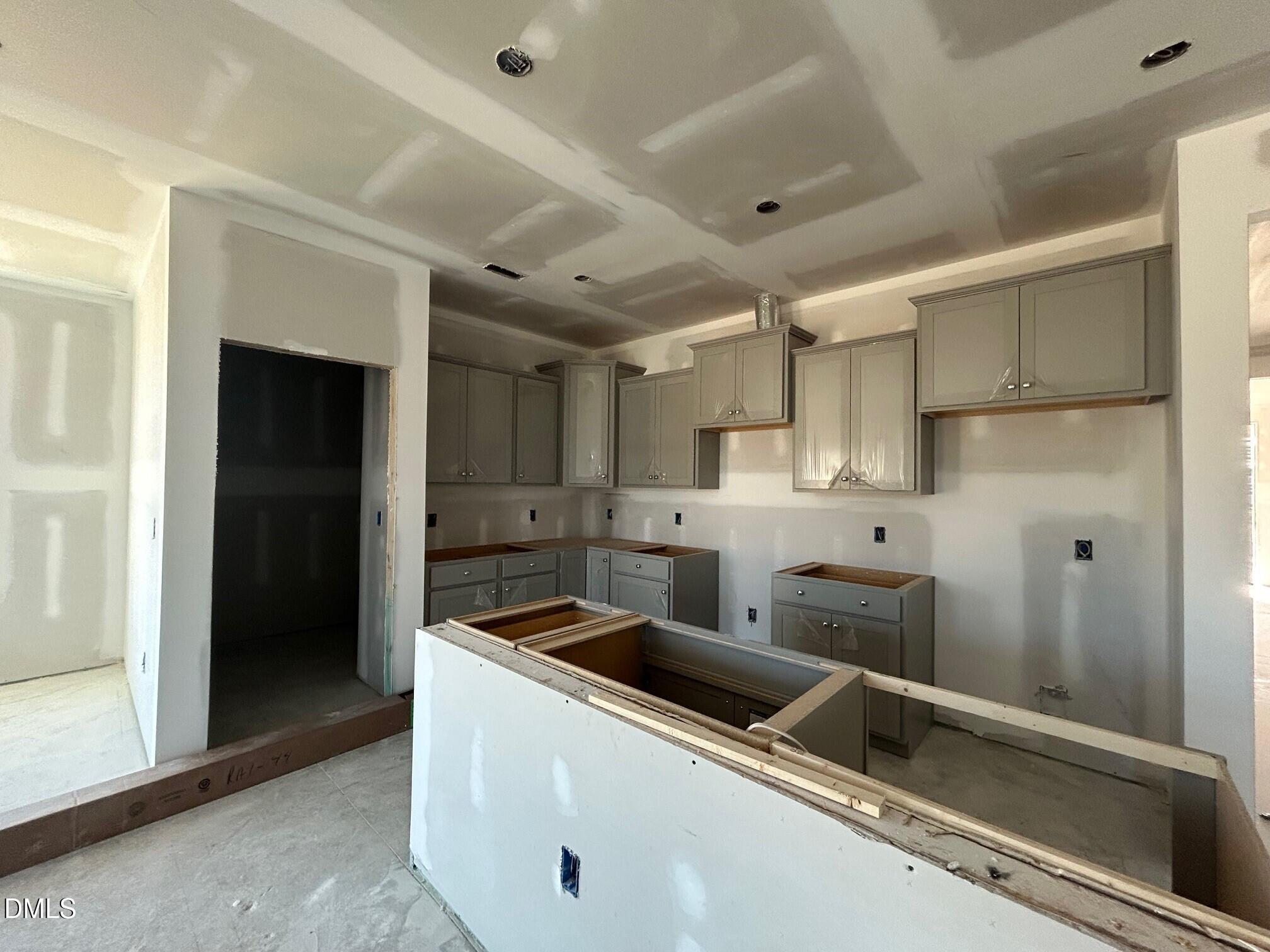 Unfinished kitchen with light cabinets, peninsula island, and recessed lighting in Davidson Homes The Daphne D, Lillington, NC