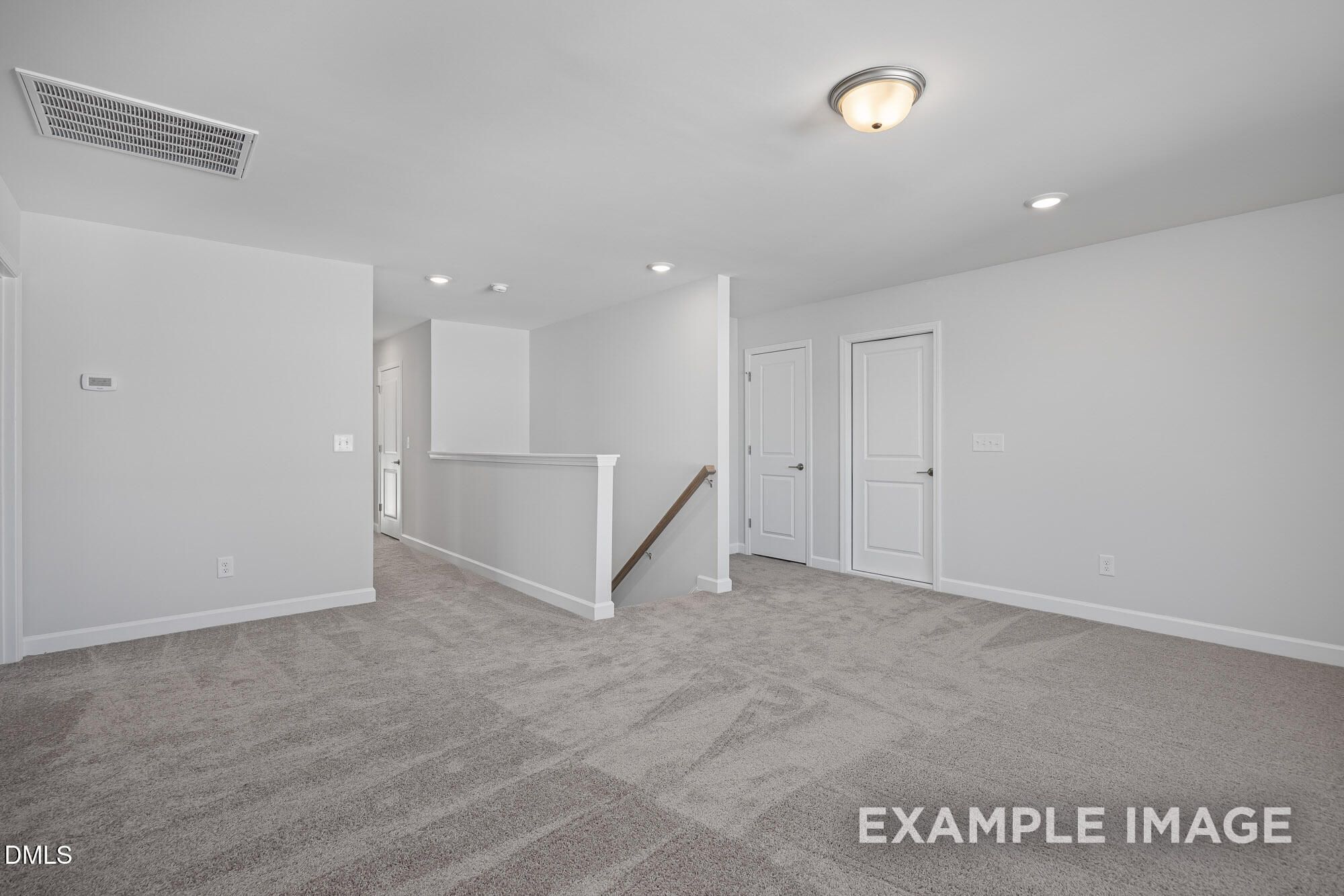 Bright upstairs hallway with white walls, beige carpet, doors, and open stair railing in Davidson Homes The Cypress B II, Angier NC
