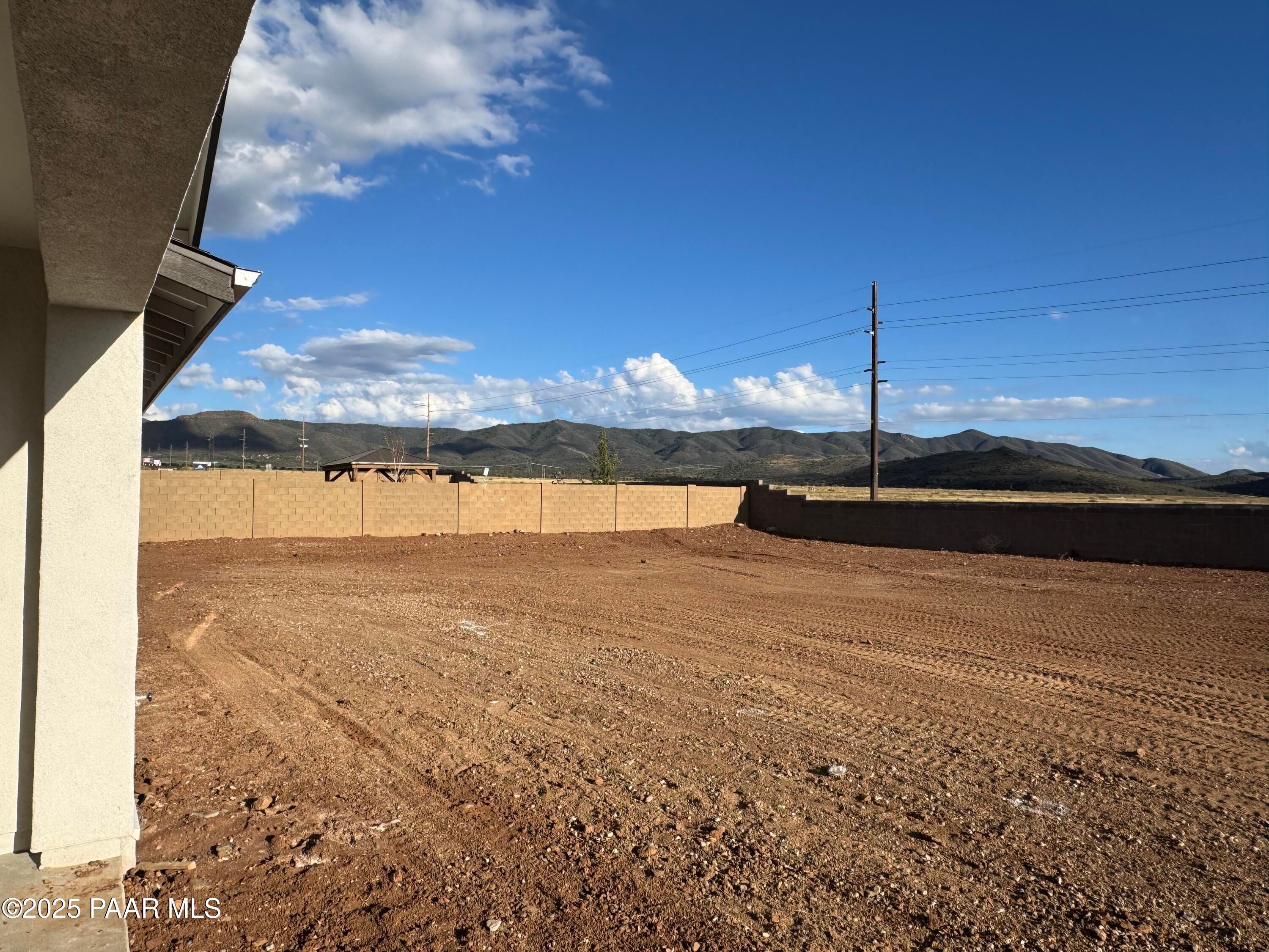 3-bedroom Evermore Homes Sunrise A exterior with expansive dirt lot, mountain views, and clear skies in Morningstar, Prescott Valley, Arizona