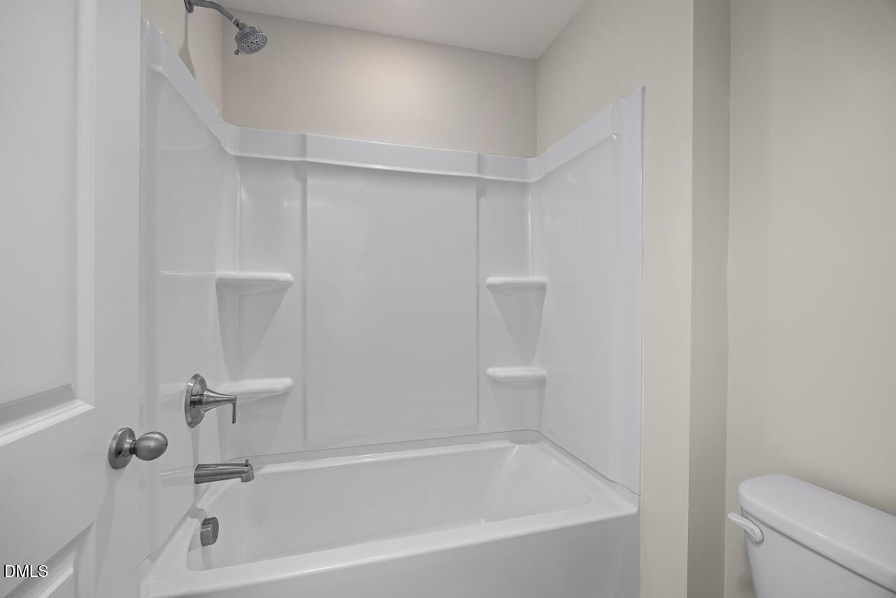 Full bathtub and shower combo with white surround in The Mitchell model home at Camden Park, Knightdale, North Carolina.