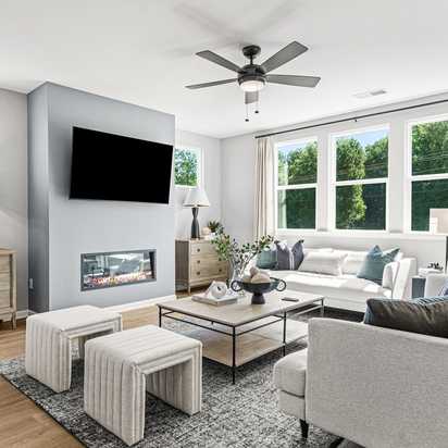 Open-concept kitchen dining living area in Fern Hollow Buford GA with white quartz island hardwood floors pendant lights