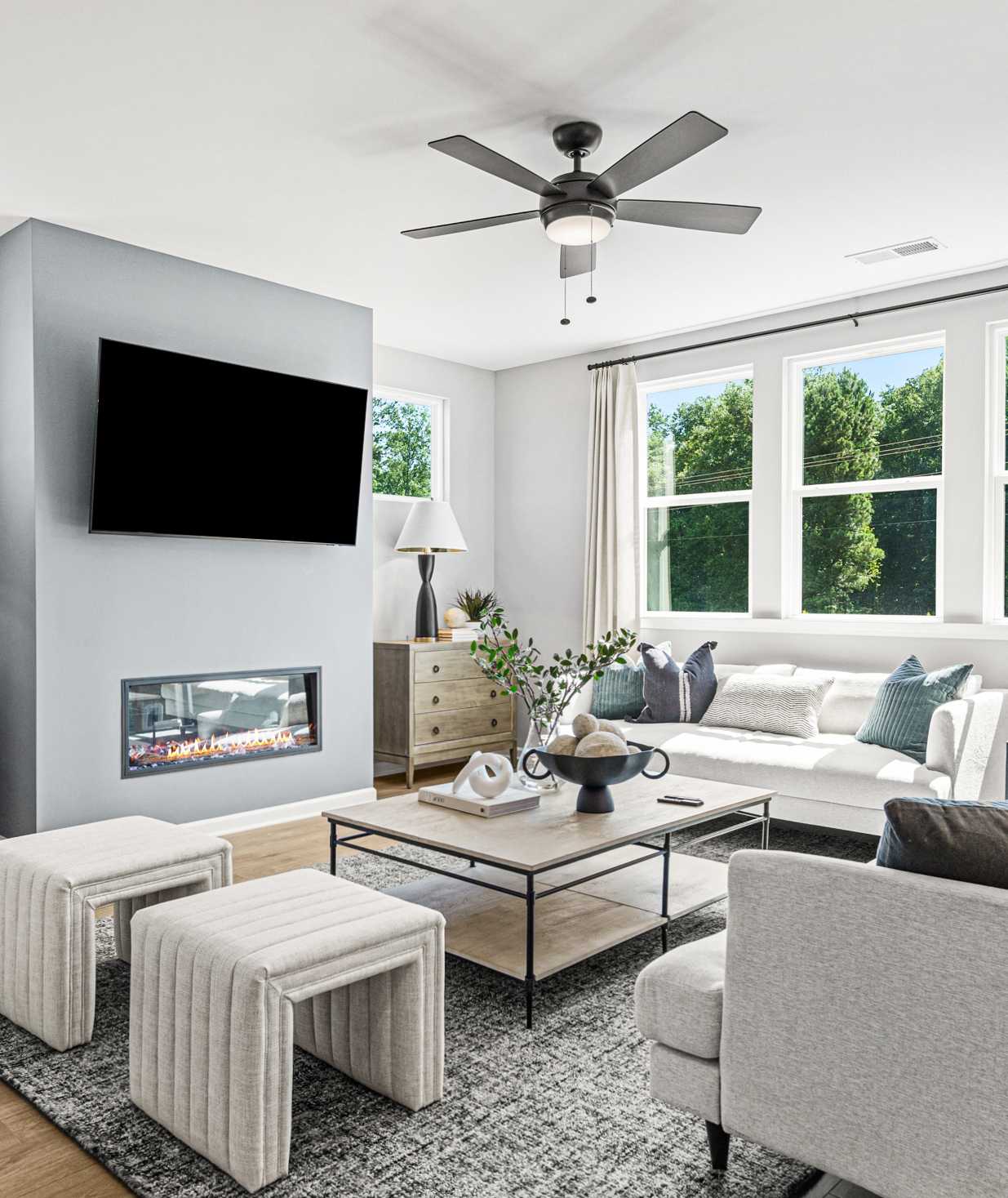 Open-concept kitchen dining living area in Fern Hollow Buford GA with white quartz island hardwood floors pendant lights