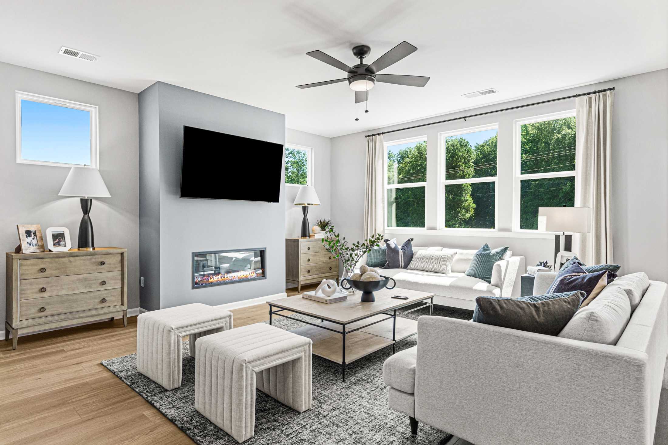 Open-concept kitchen dining living area in Fern Hollow Buford GA with white quartz island hardwood floors pendant lights