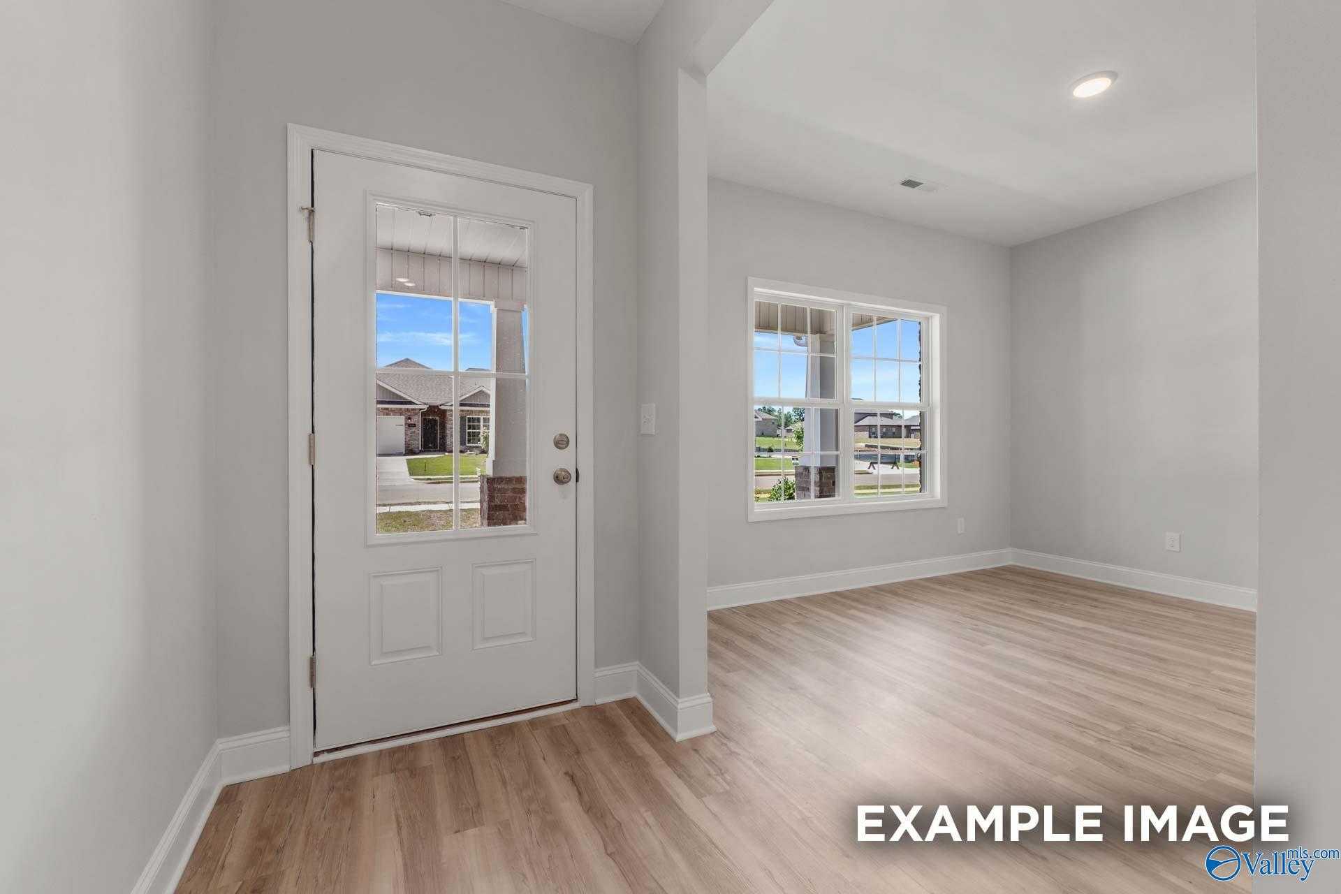 Bright entryway with hardwood floors, large windows, and glass door overlooking neighborhood in Davidson Homes The Shelby C, Meridianville, AL