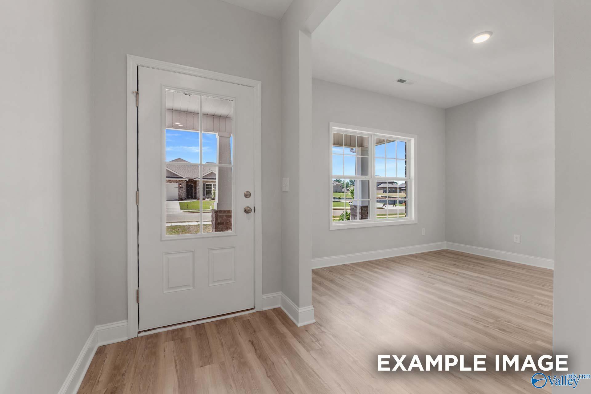 Bright entryway with hardwood floors, large windows, and glass door overlooking neighborhood in Davidson Homes The Shelby C, Meridianville, AL