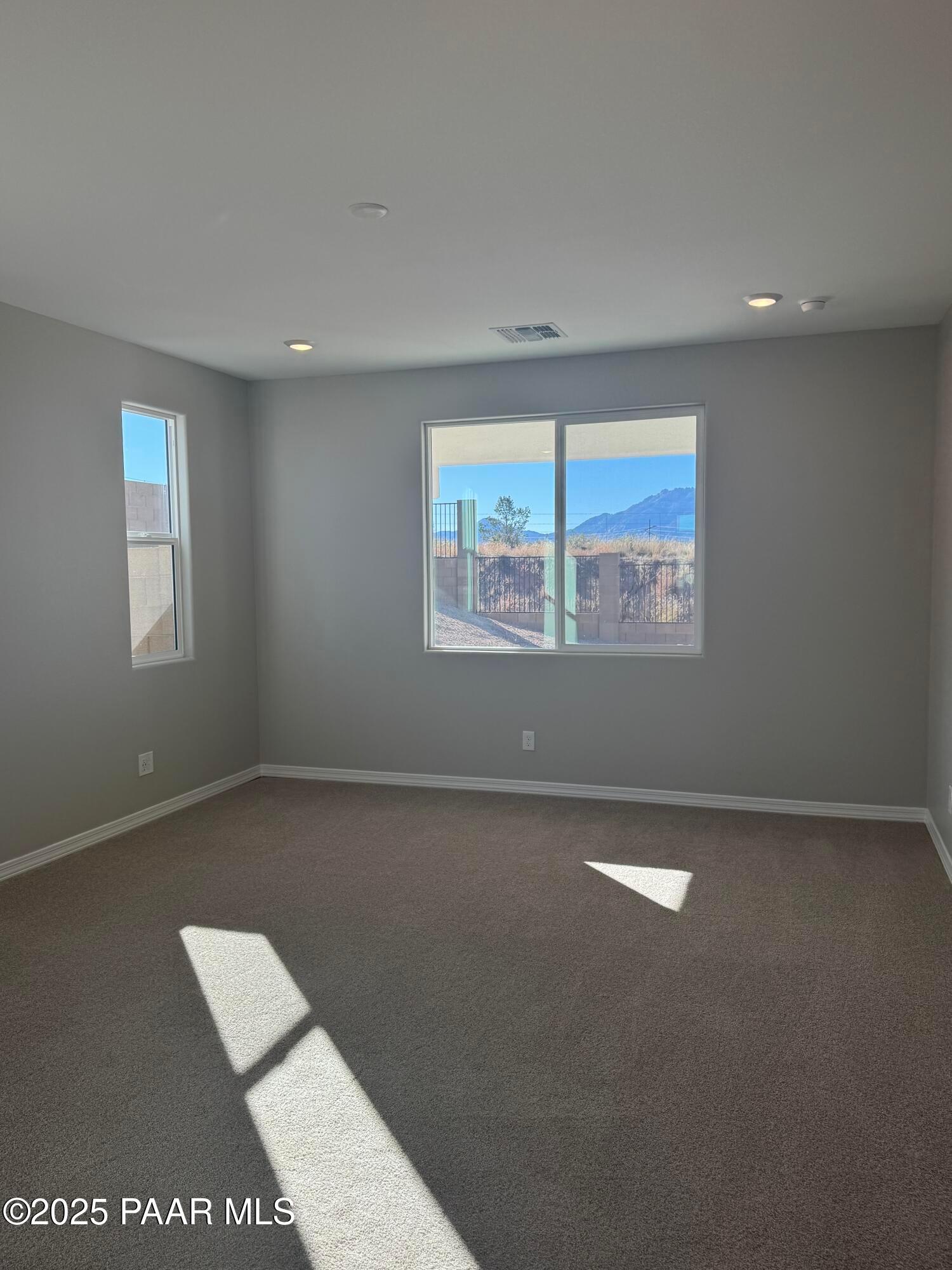 Sunlit empty room with gray walls, large windows overlooking desert mountains in 3-bedroom Davidson Homes The Monarch E, Prescott AZ