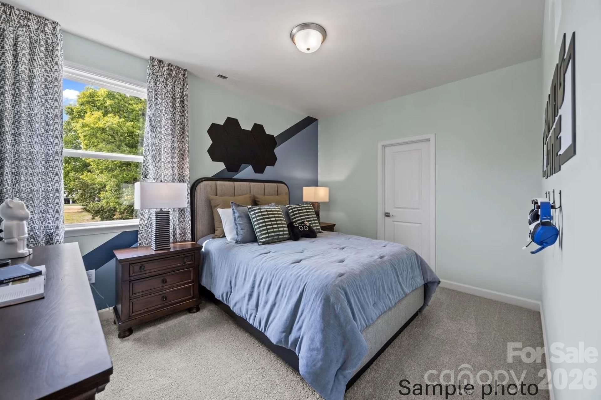 Modern bedroom with blue accent wall and geometric decor in The Beech B floor plan at Enclave at Belmont, North Carolina.