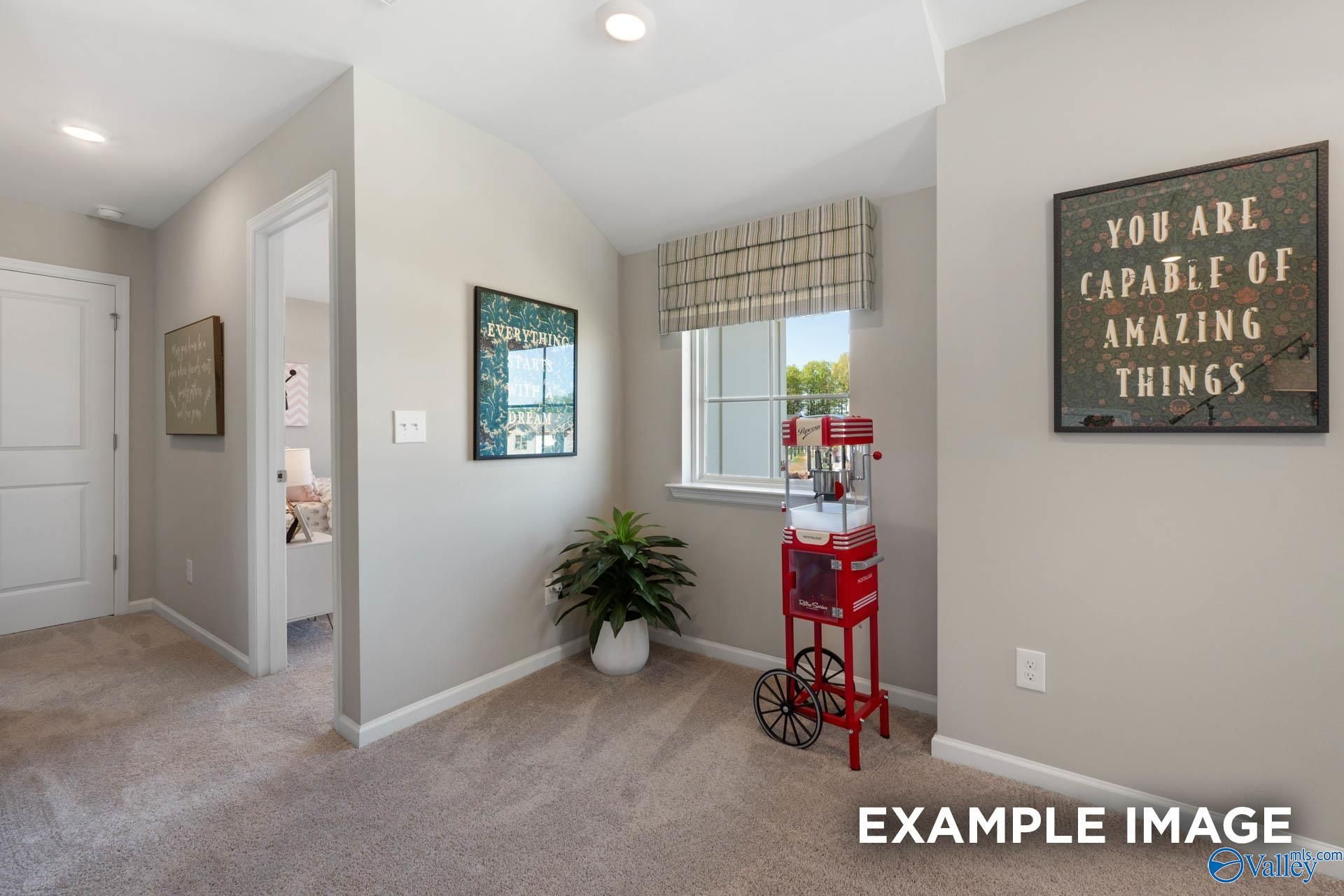 Upstairs hallway with motivational wall art, potted plant, red serving cart in Davidson Homes The Stella, Evergreen Mill, Madison AL