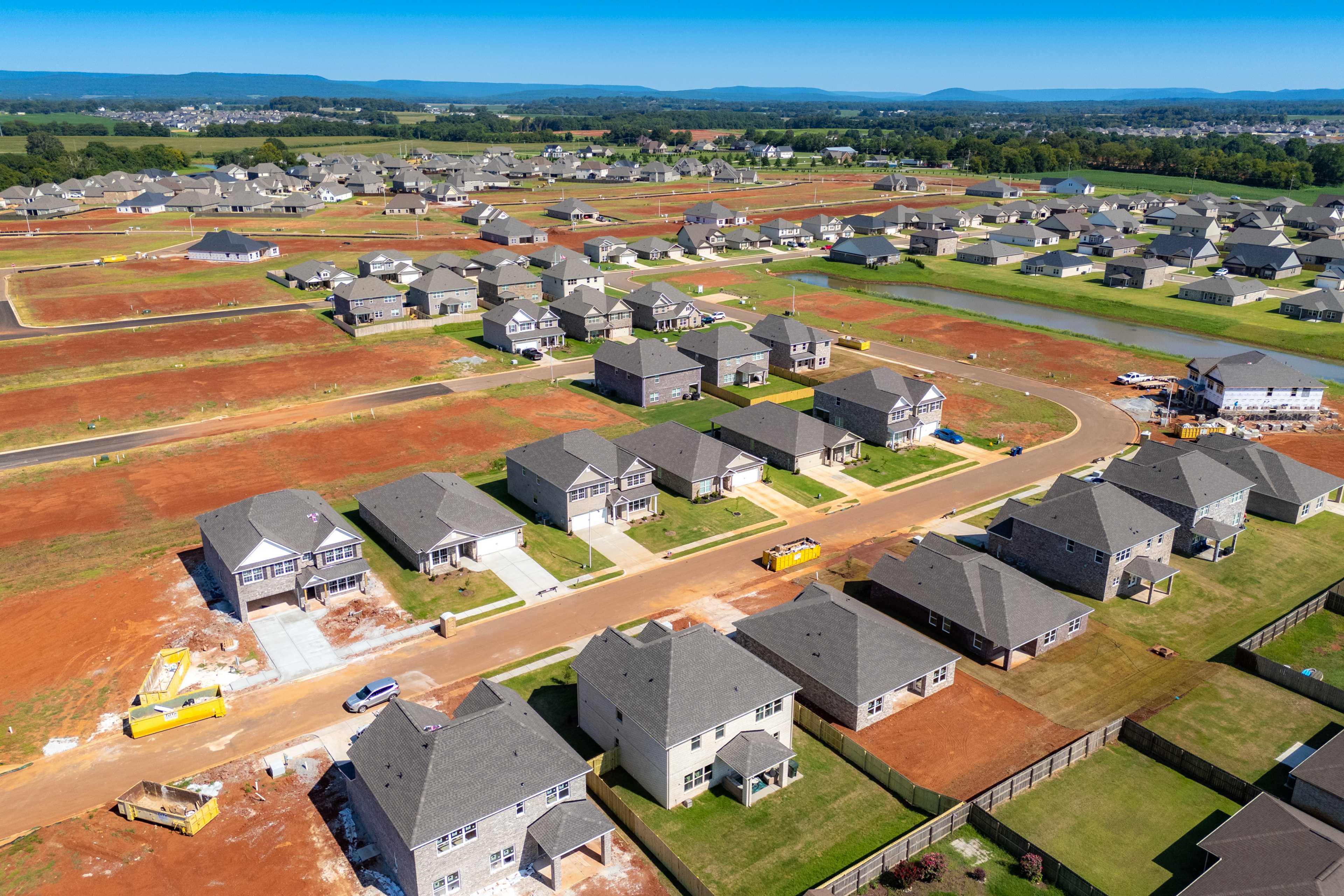 Aerial view of Walker's Hill neighborhood in Meridianville Alabama showcasing new Davidson Homes on red clay lots with green lawns and distant hills