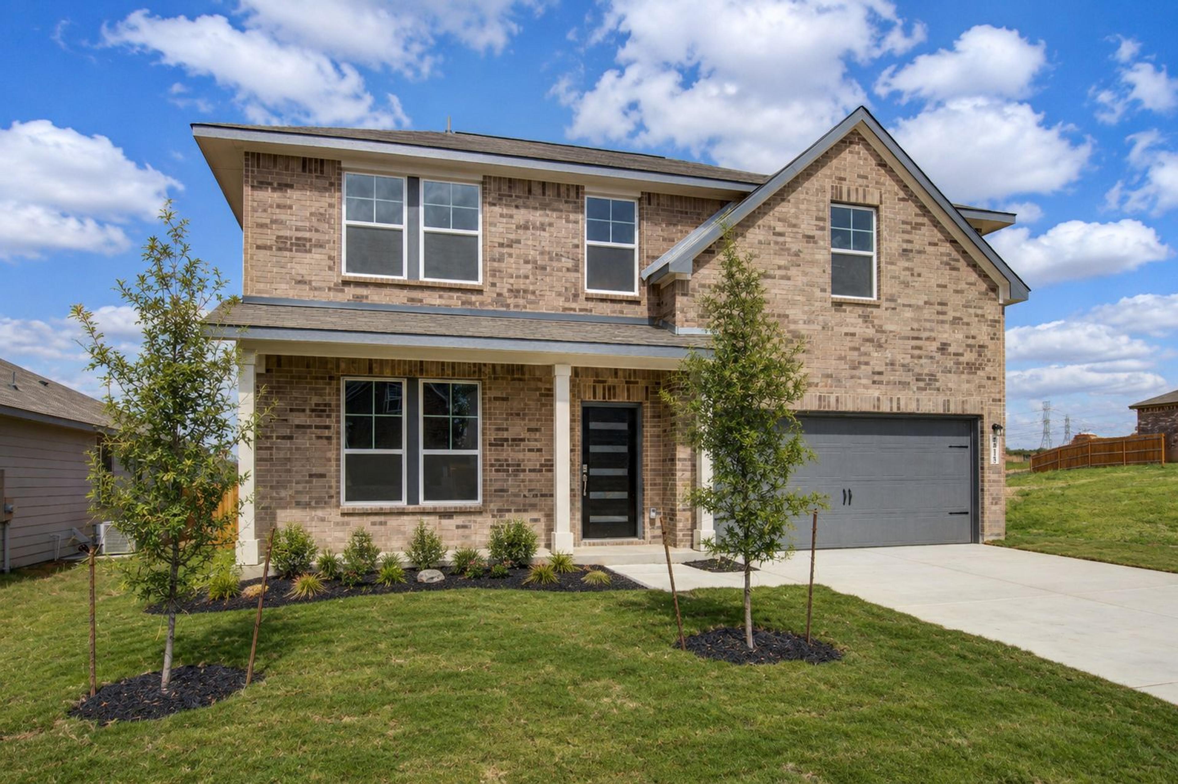 Spacious modern kitchen in Horizon Pointe Converse Texas with white shaker cabinets quartz island stainless appliances hardwood floors